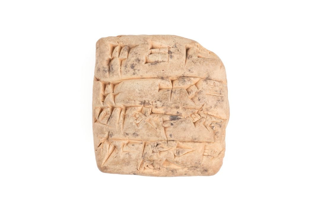 Terracotta tablet featuring nine horizontal lines of Sumerian cuneiform incised pictographic script on the obverse and reverse.