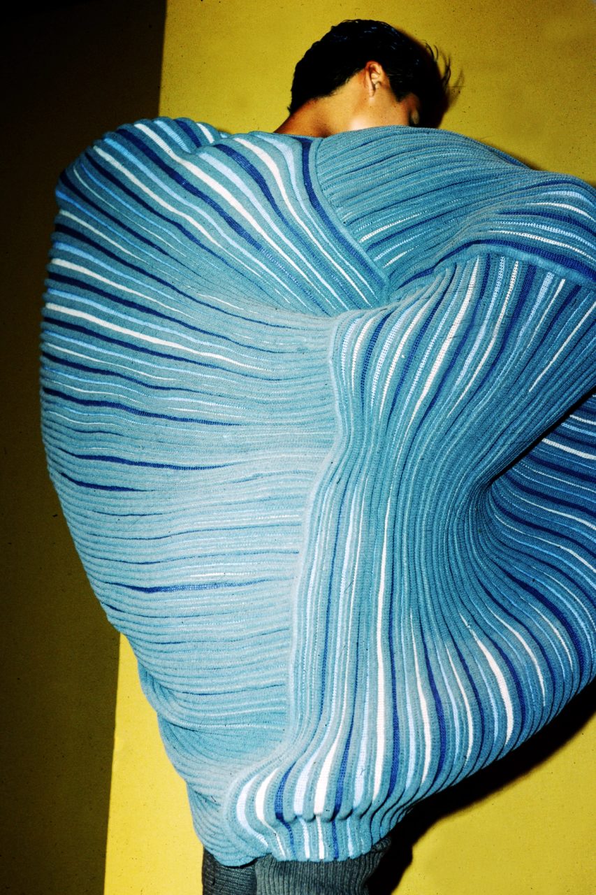 Photograph of model wearing blue striped knit garment from the Issey Miyake Paris Spring Summer 1985 collection.