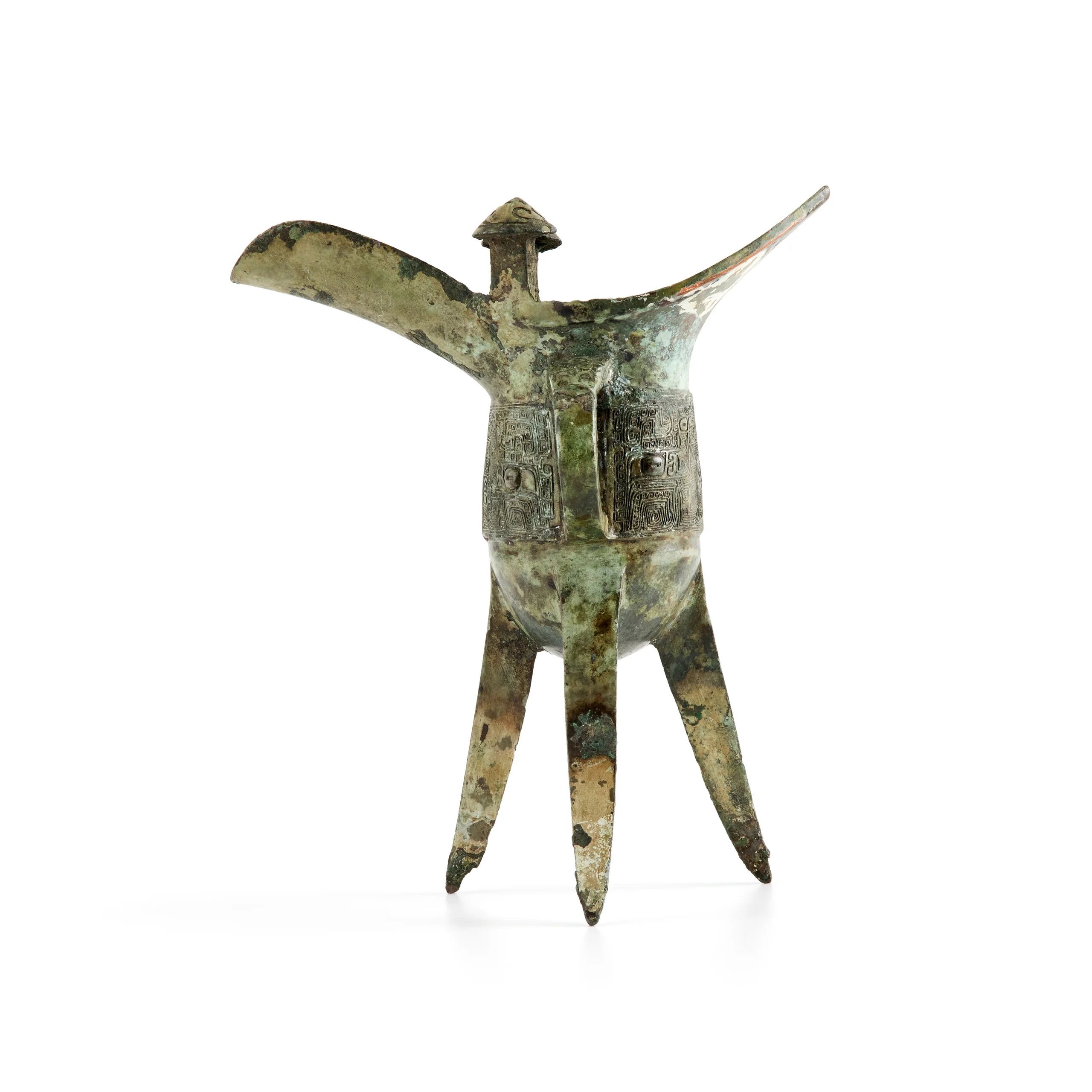 A bronze wine vessel with a 'U' shaped body. Raised on tripod legs with a green patina.