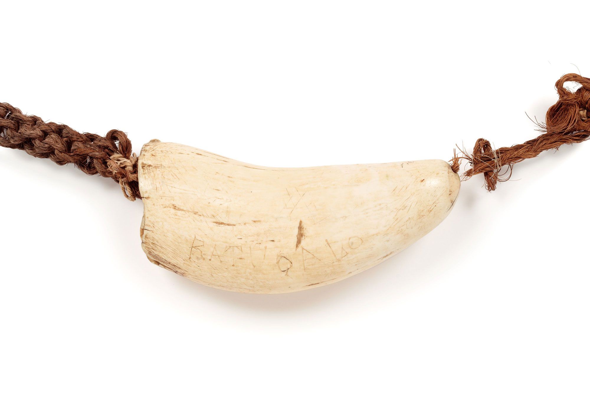 A heavy neck ornament of a large sperm whale tooth on a long platted rope made of coconut fibres.
