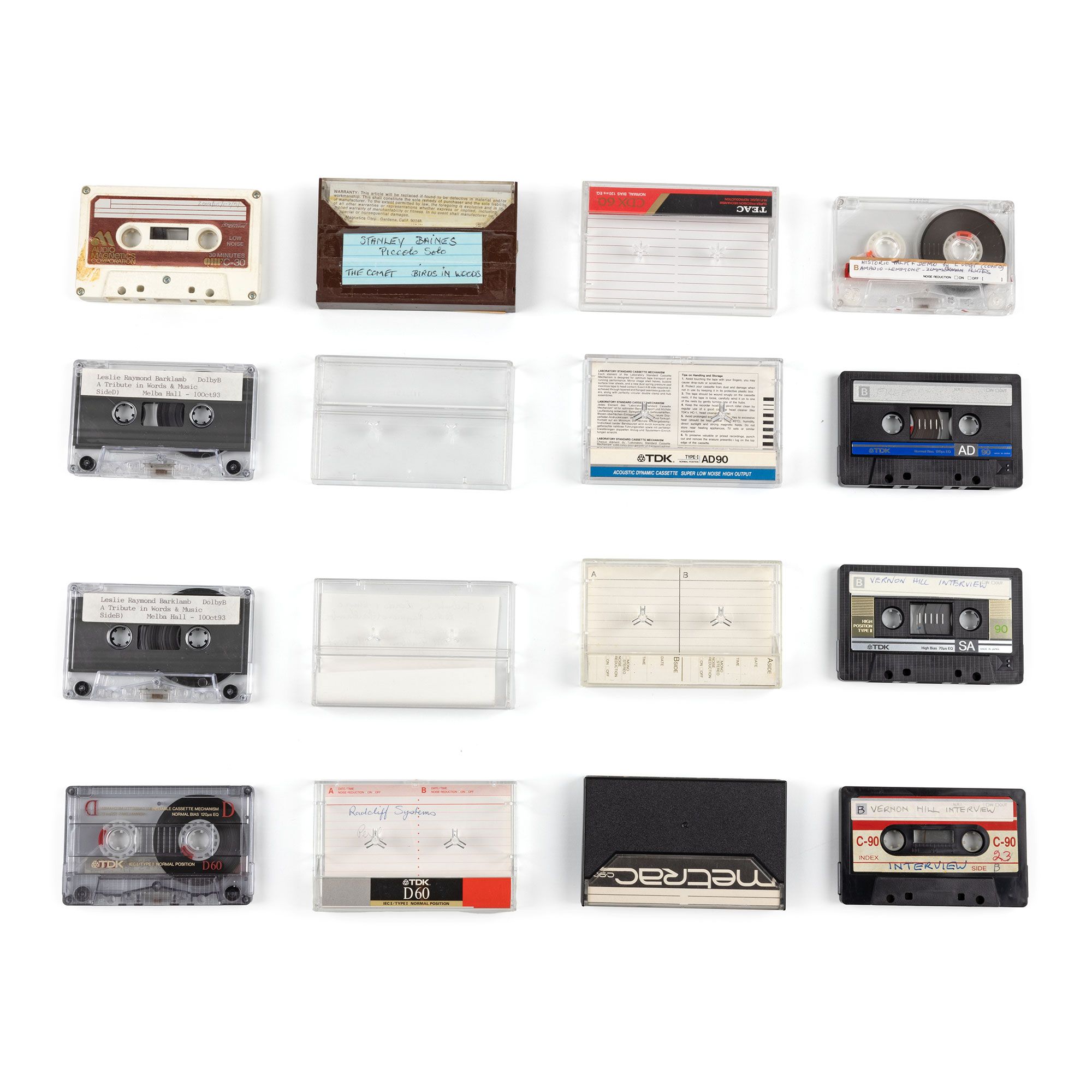 16 black, translucent and white cassette tapes laid out in a grid.