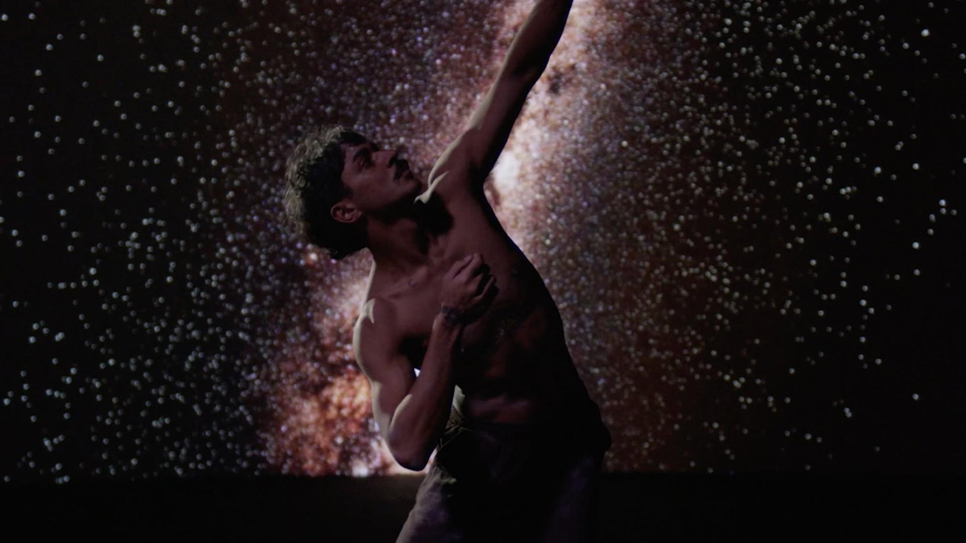 Dancing person in front of stars.