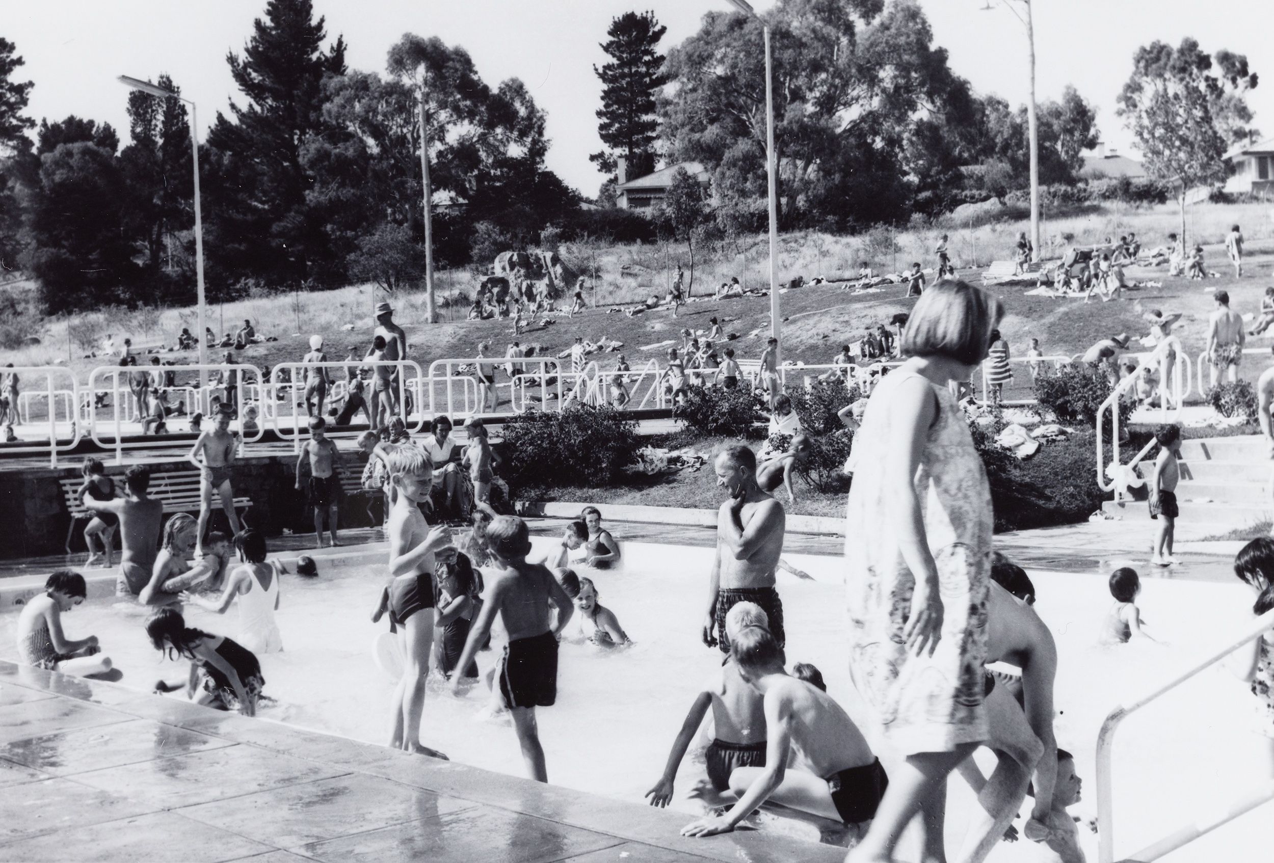 Black and white photograph of children playing in a pool.