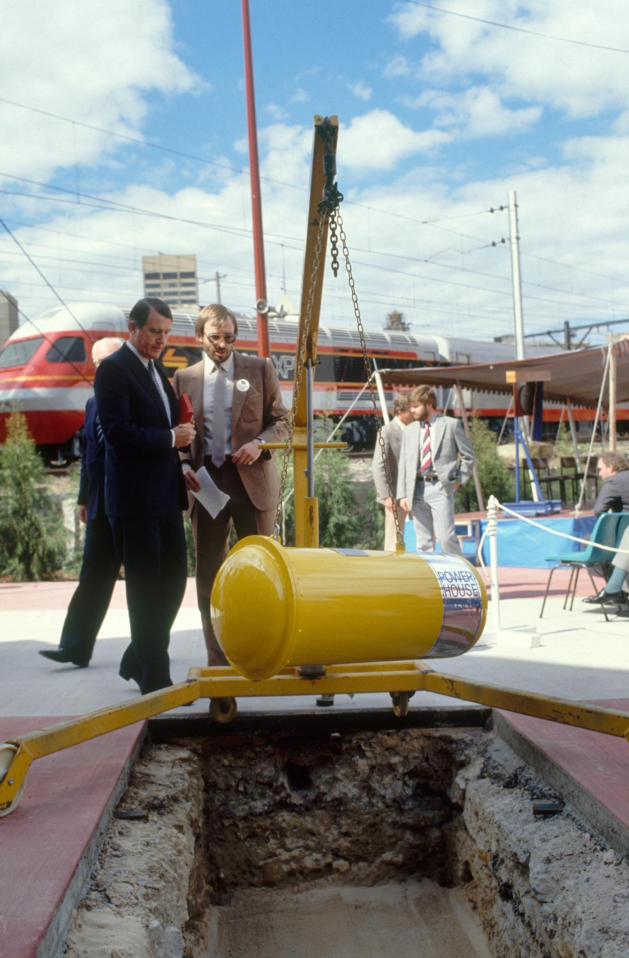 Photograph of a time capsule being lowered into the ground