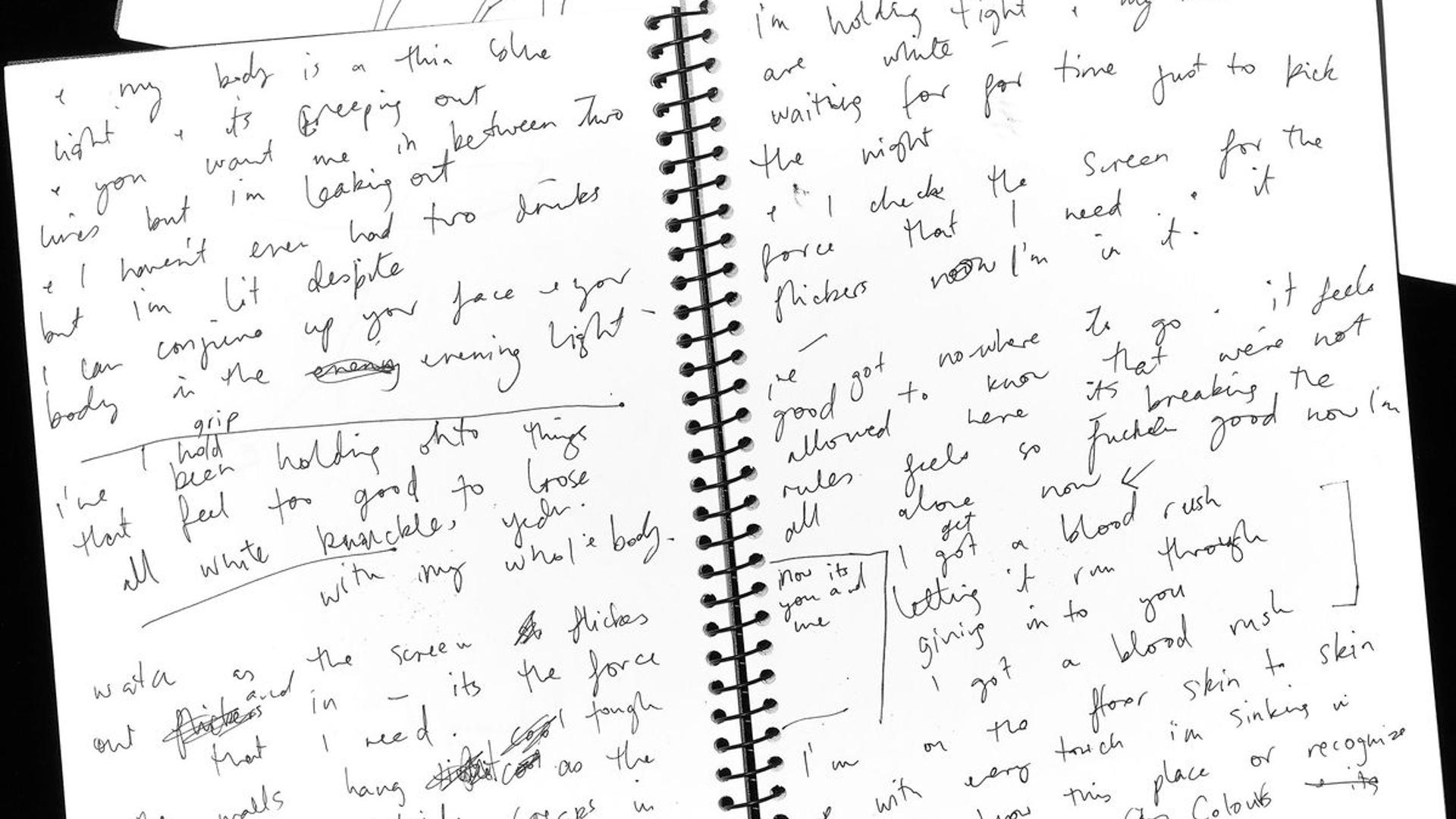 An open spiral bound notebook with handwritten notes.