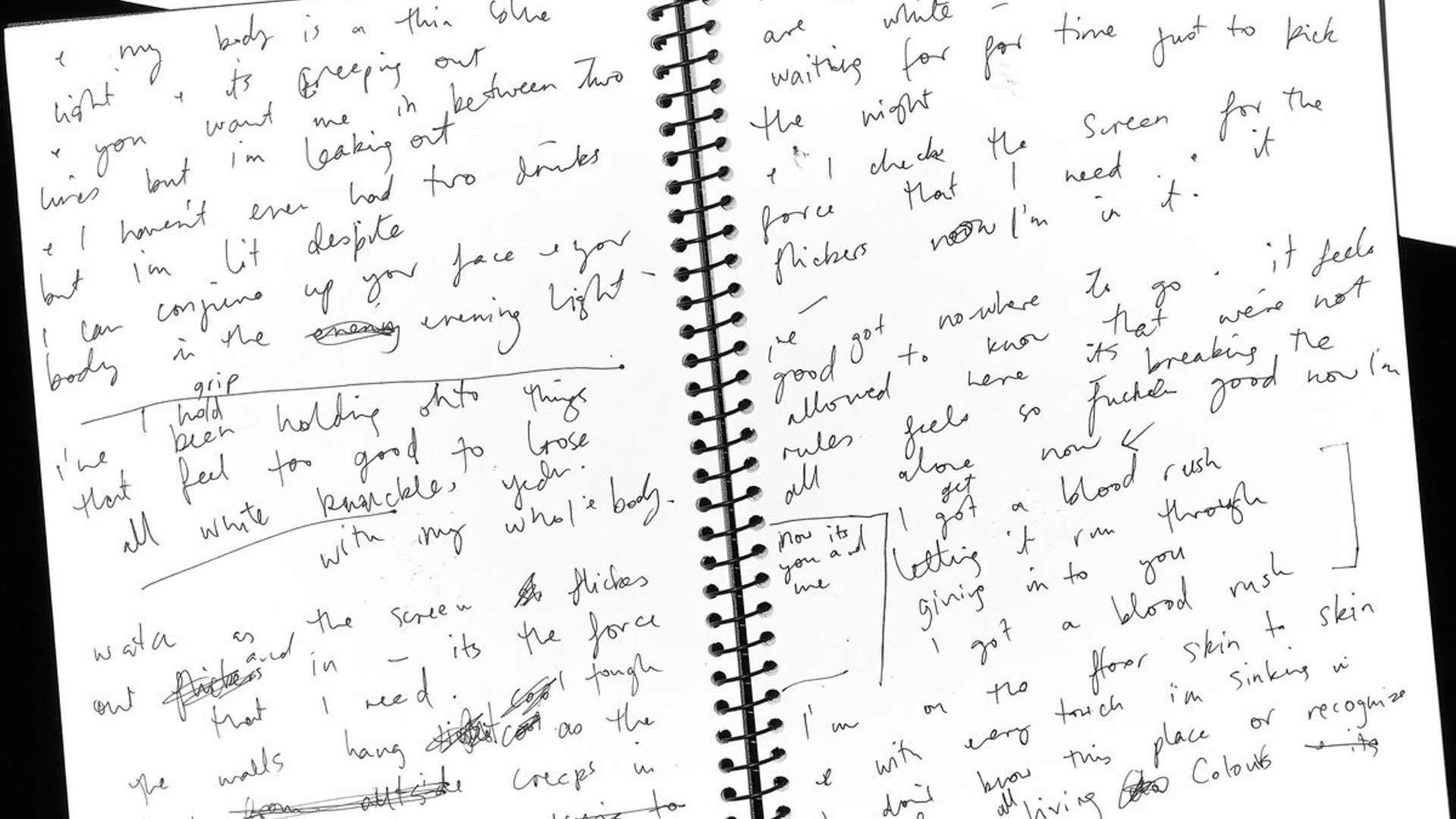 An open spiral bound notebook with handwritten notes.