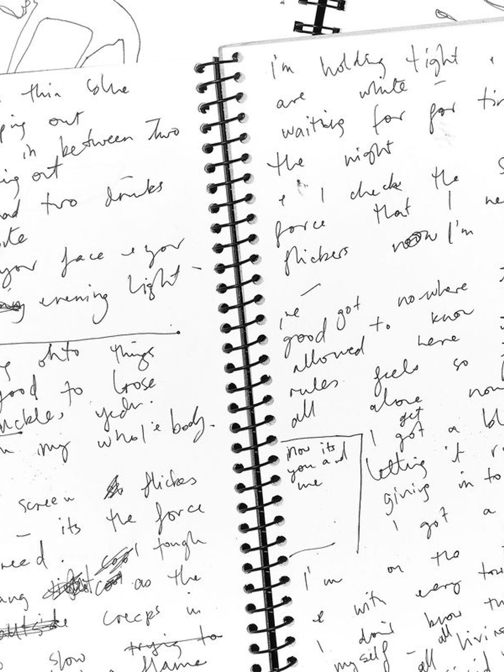 An open spiral bound notebook with handwritten notes.