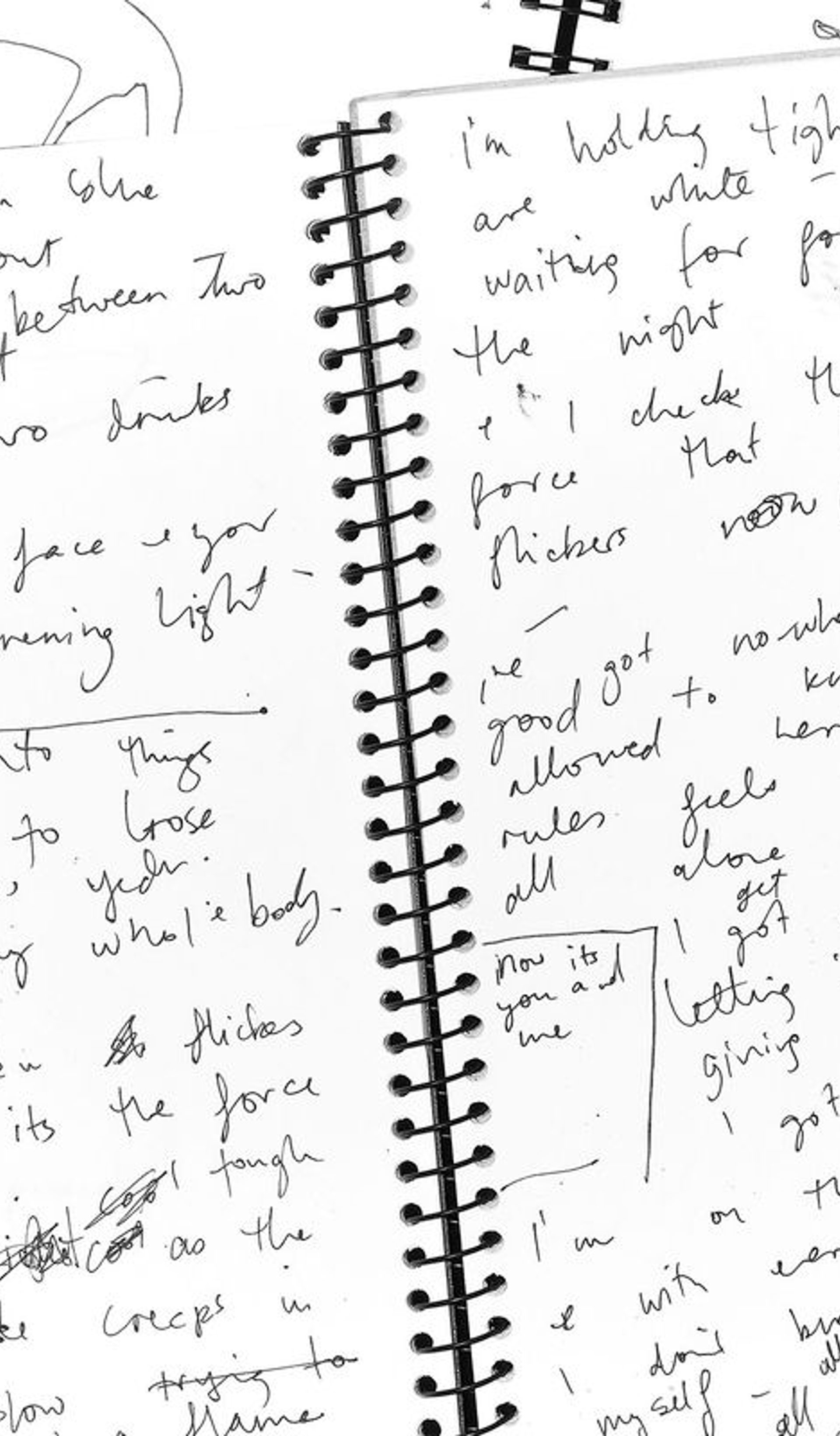 An open spiral bound notebook with handwritten notes.