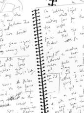 An open spiral bound notebook with handwritten notes.