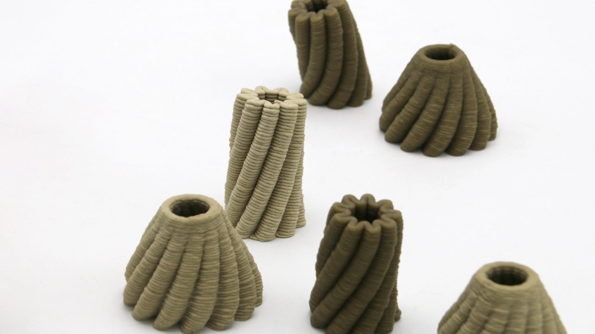A 3D printer prints a brown, bowl-shaped object with scalloped edges.