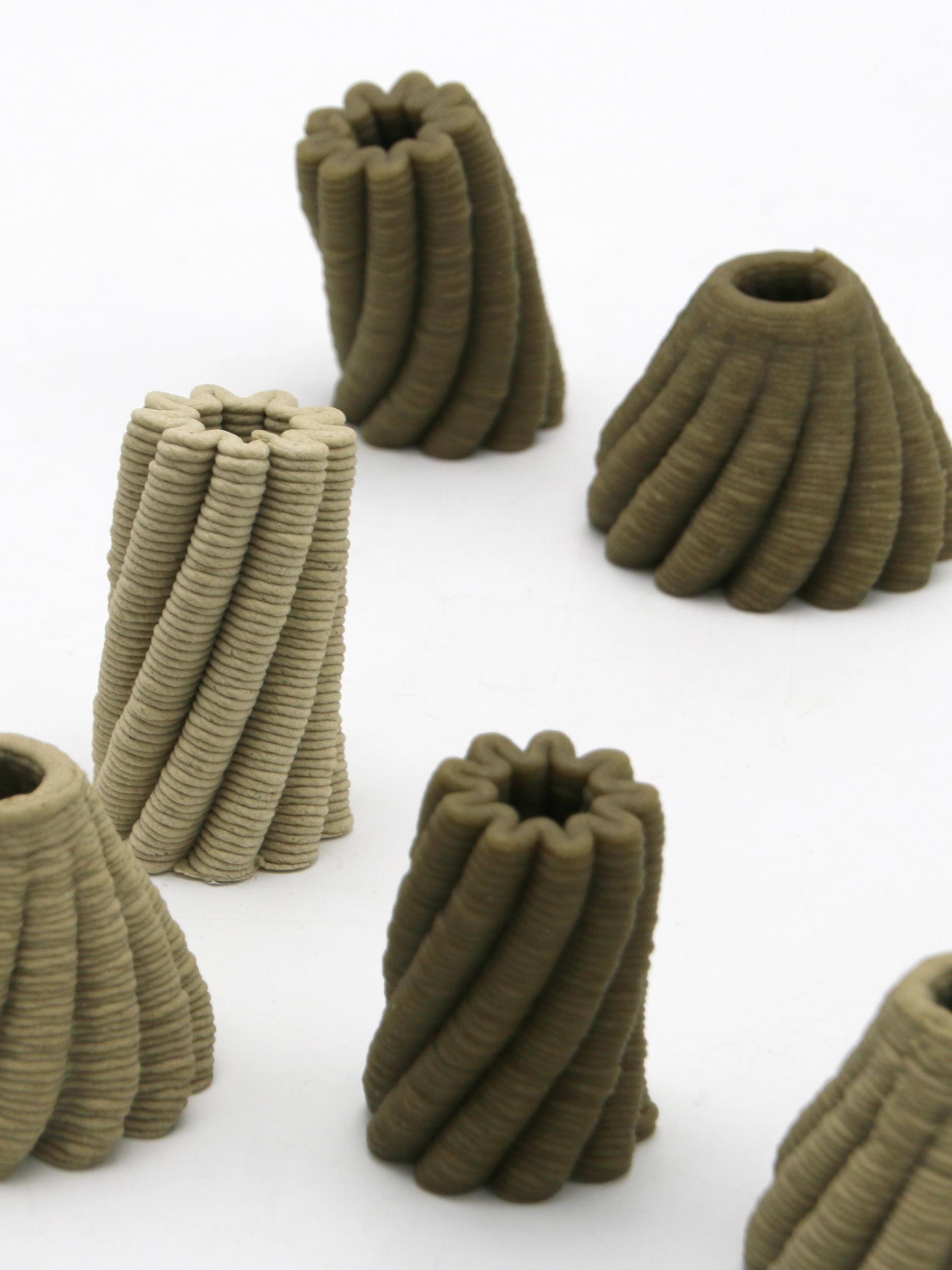 A 3D printer prints a brown, bowl-shaped object with scalloped edges.