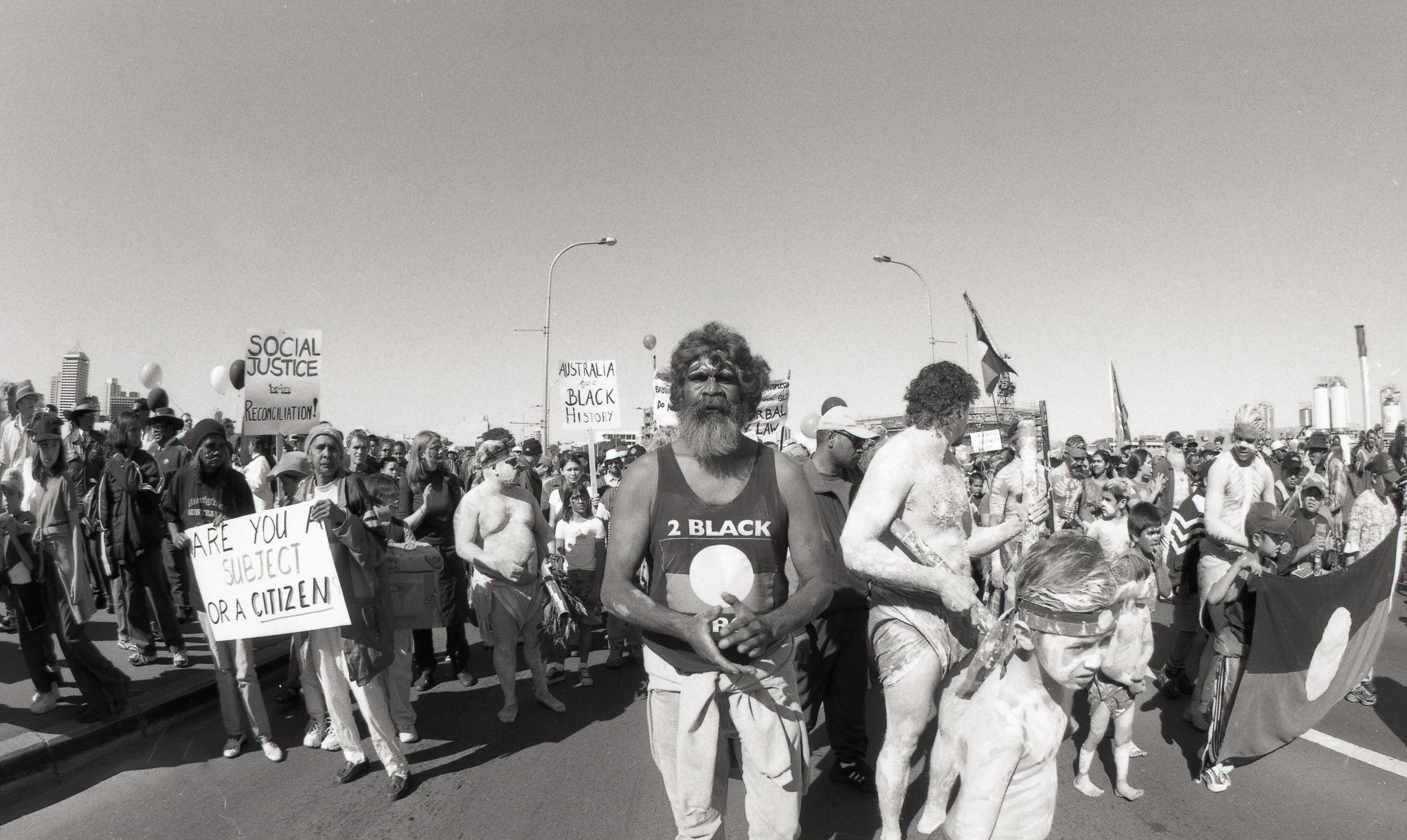 A group of Australian First Nations people marching on the road.