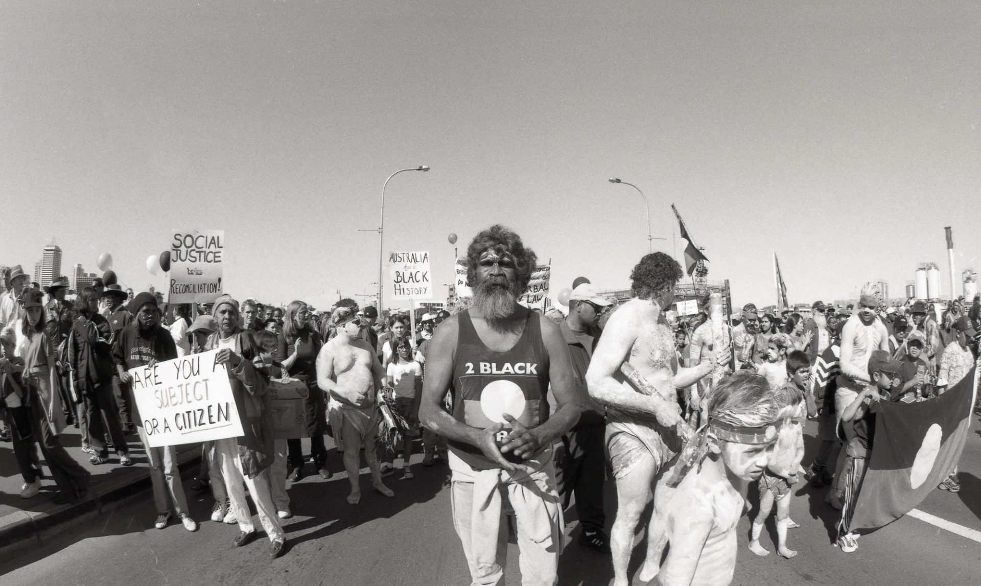 A group of Australian First Nations people marching on the road.