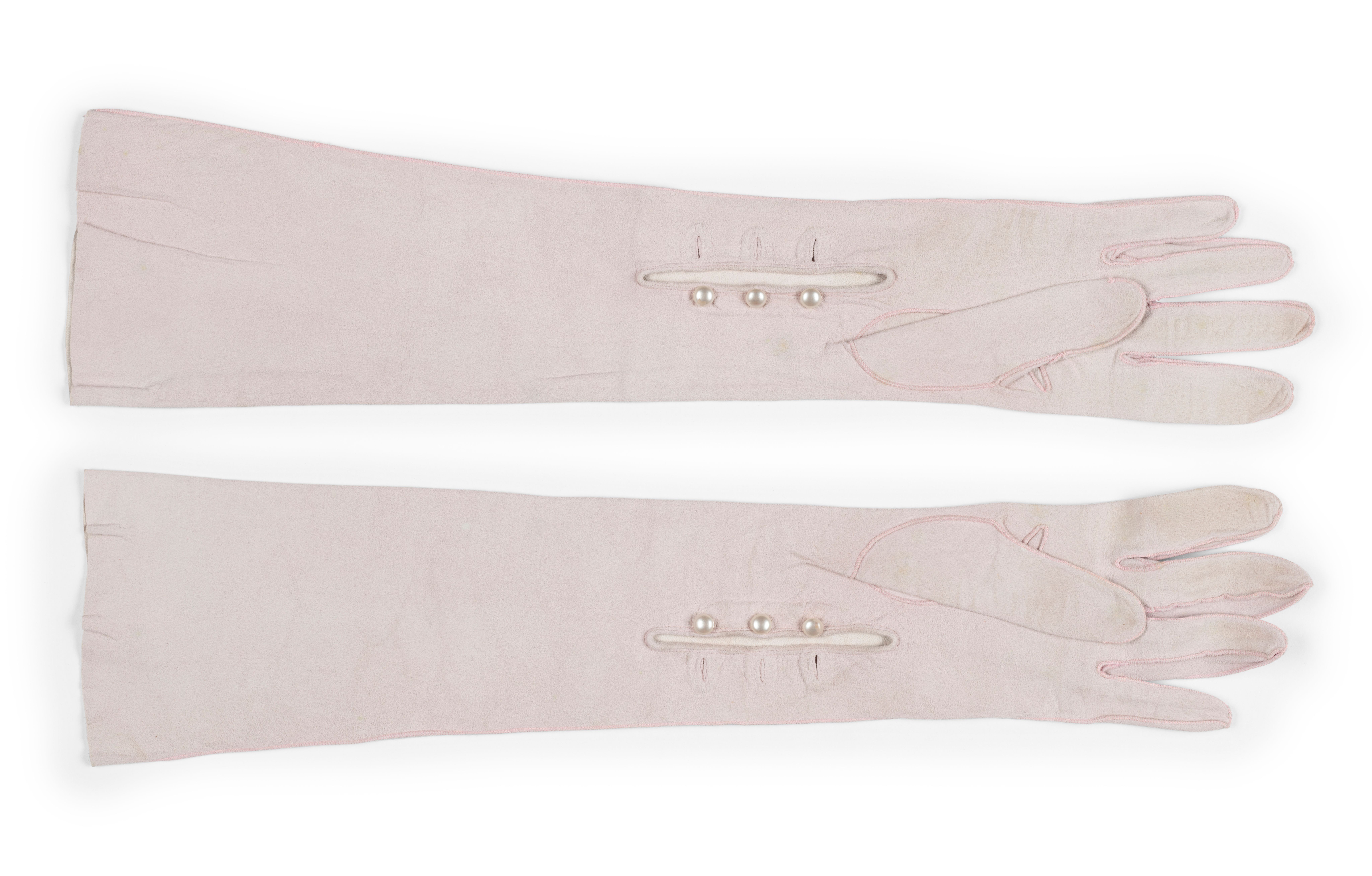 Light pink gloves, mid-forearm length, made of kid leather.