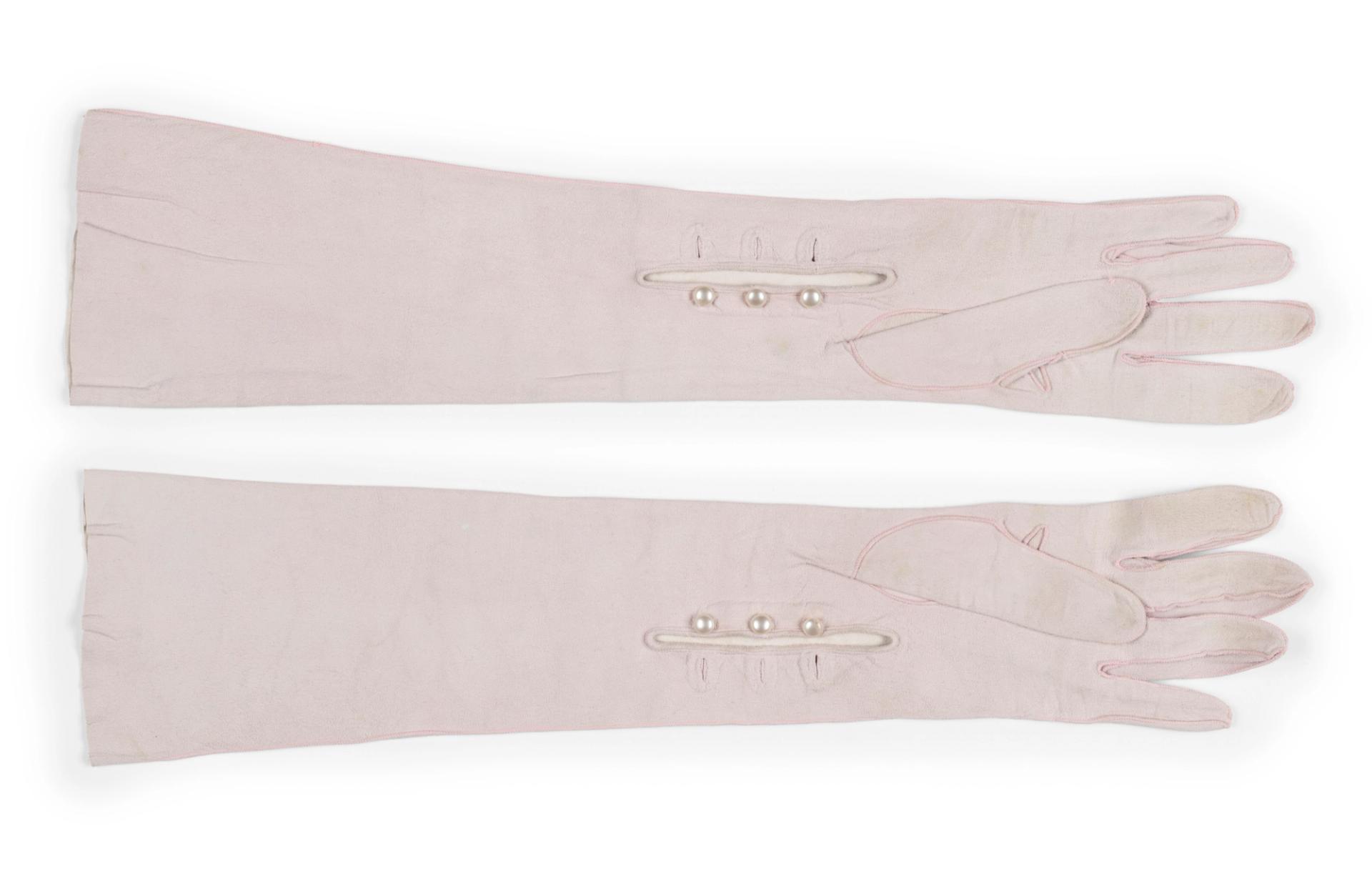 Light pink gloves, mid-forearm length, made of kid leather.