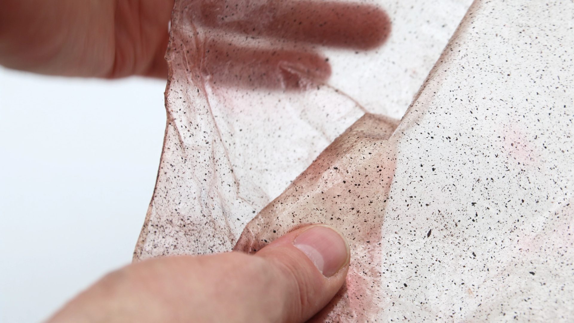 Two hands holding a flexible sheet of bio plastics