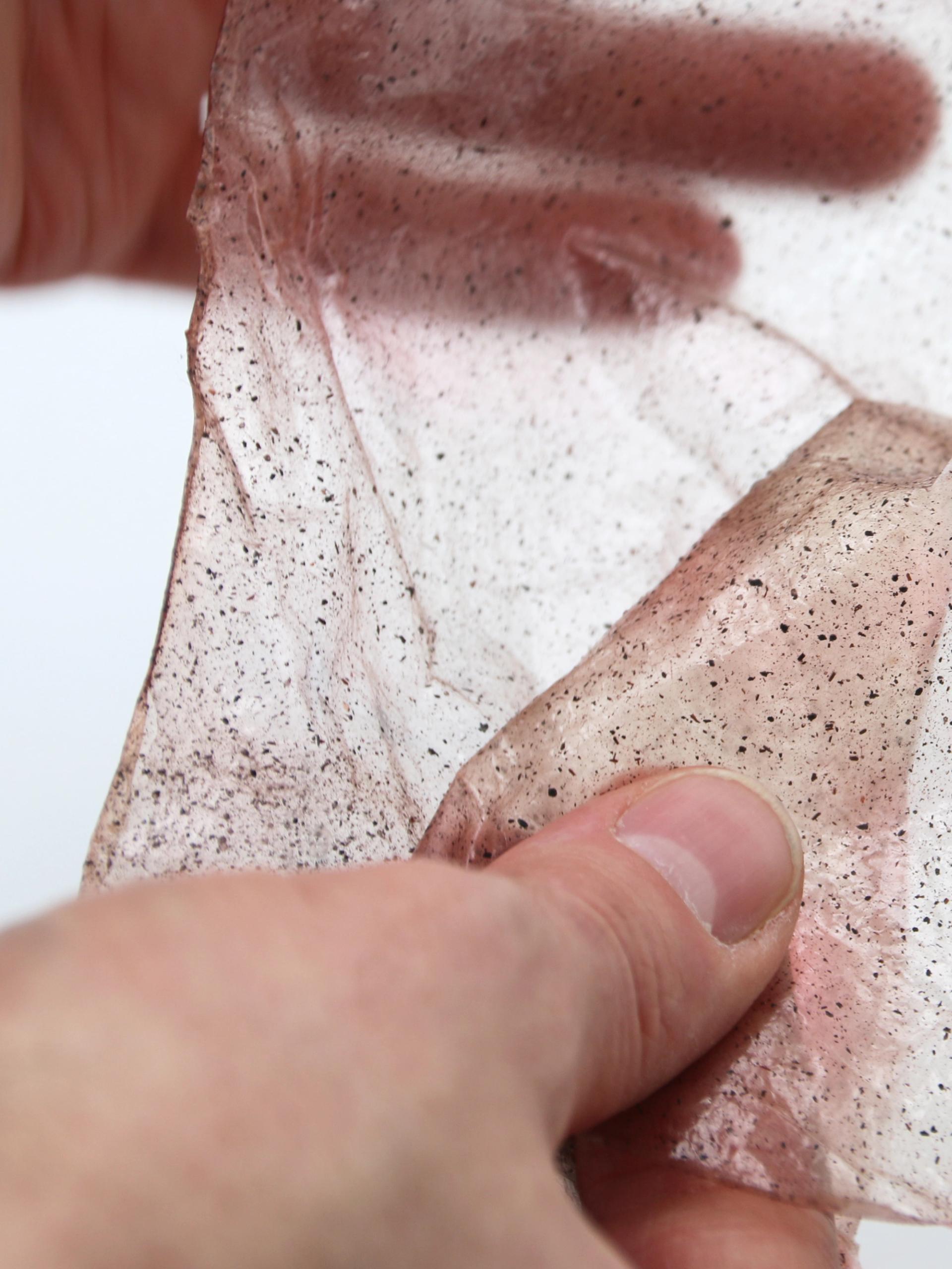 Two hands holding a flexible sheet of bio plastics