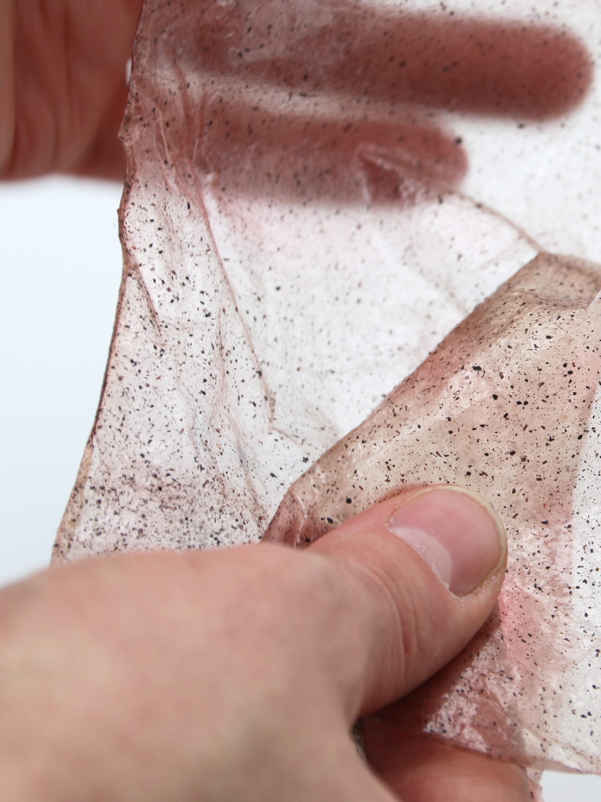 Two hands holding a flexible sheet of bio plastics