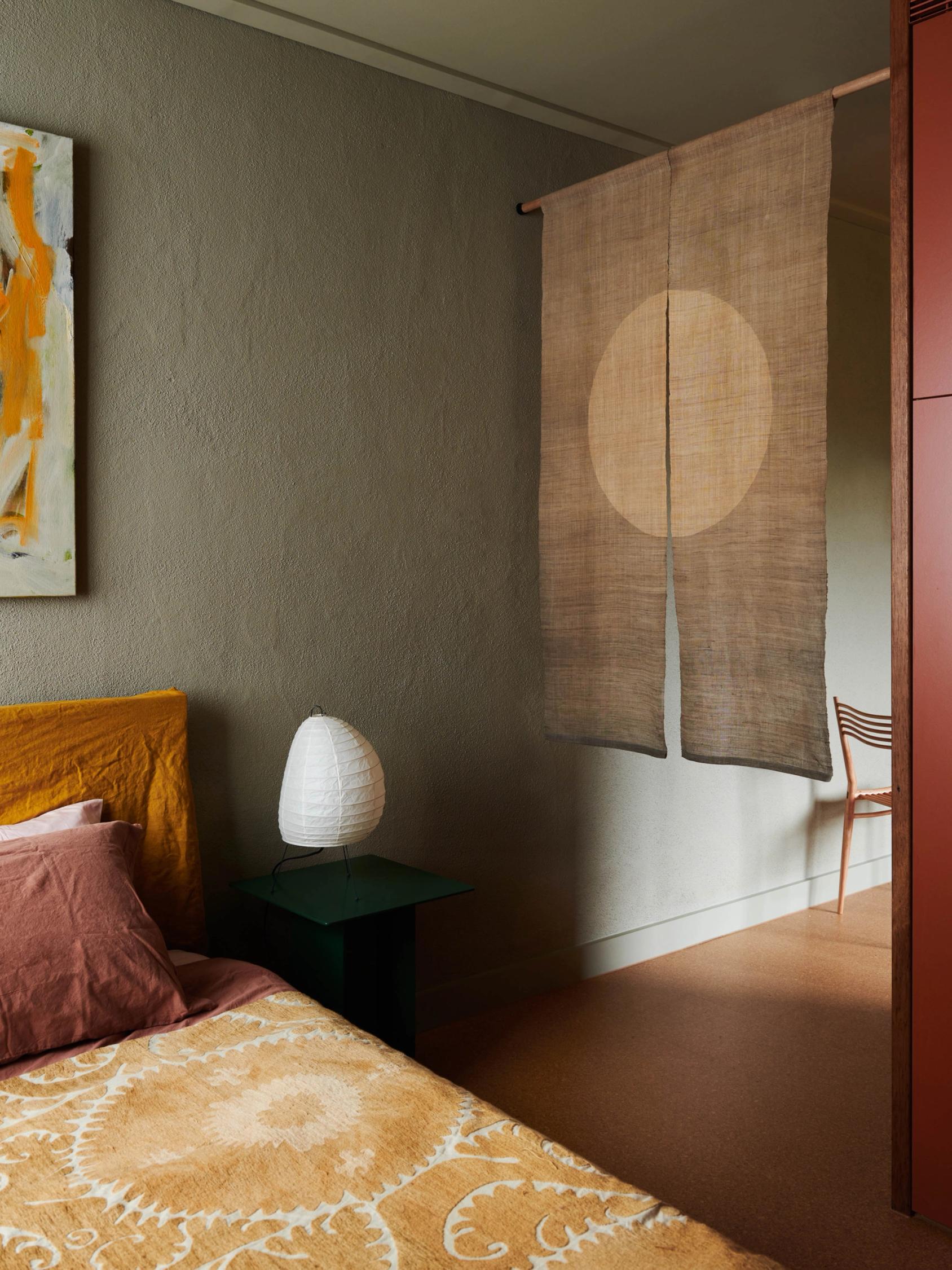 Camera atop the bed, facing the entrance covered by a Japanese curtain.