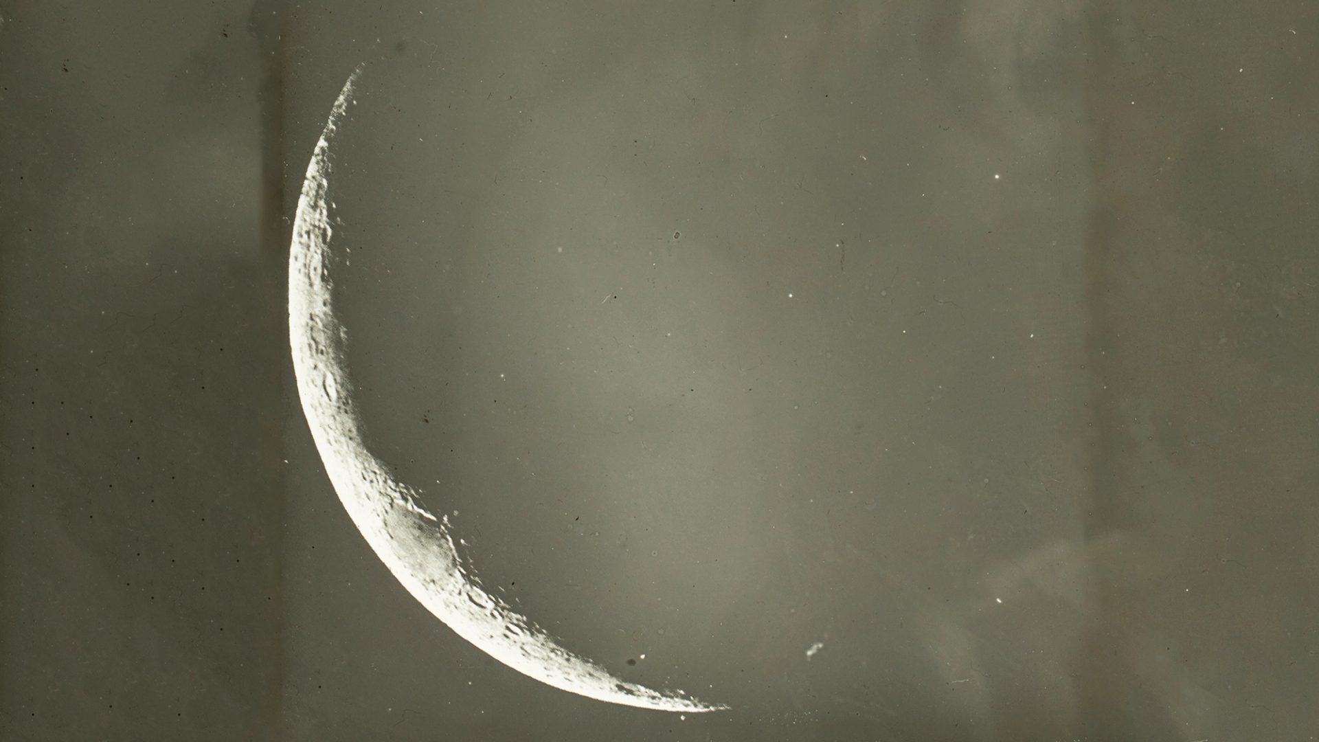 A close up of a glass plate slide showing a thin crescent moon.