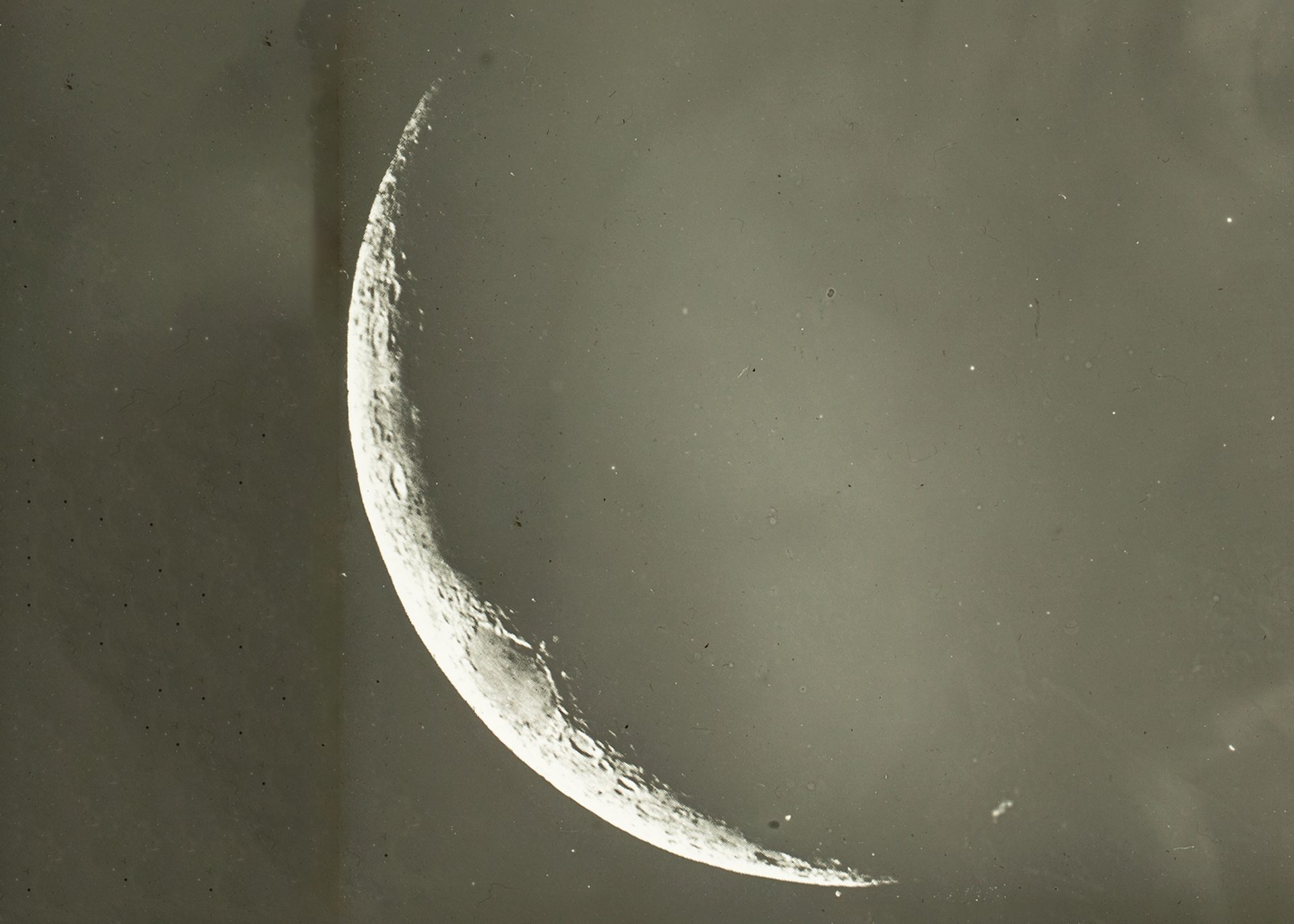 A close up of a glass plate slide showing a thin crescent moon.