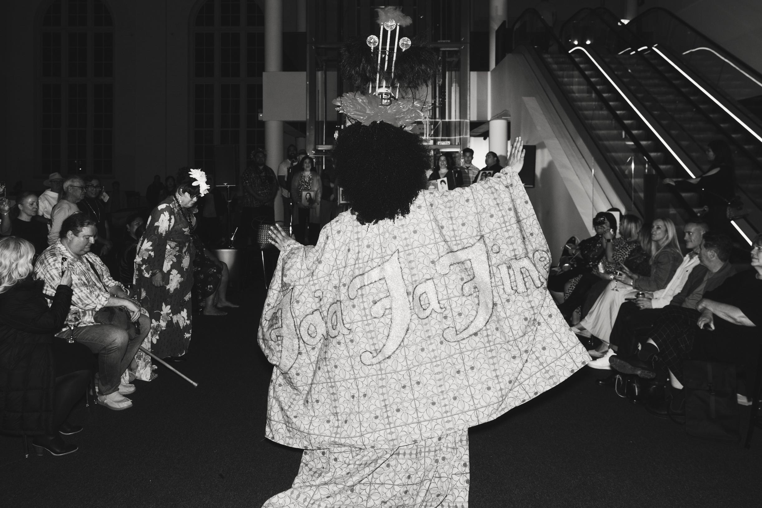 BERTHA, a drag queen performing in a kimono embroidered with large text reading ‘fa’afafine.’