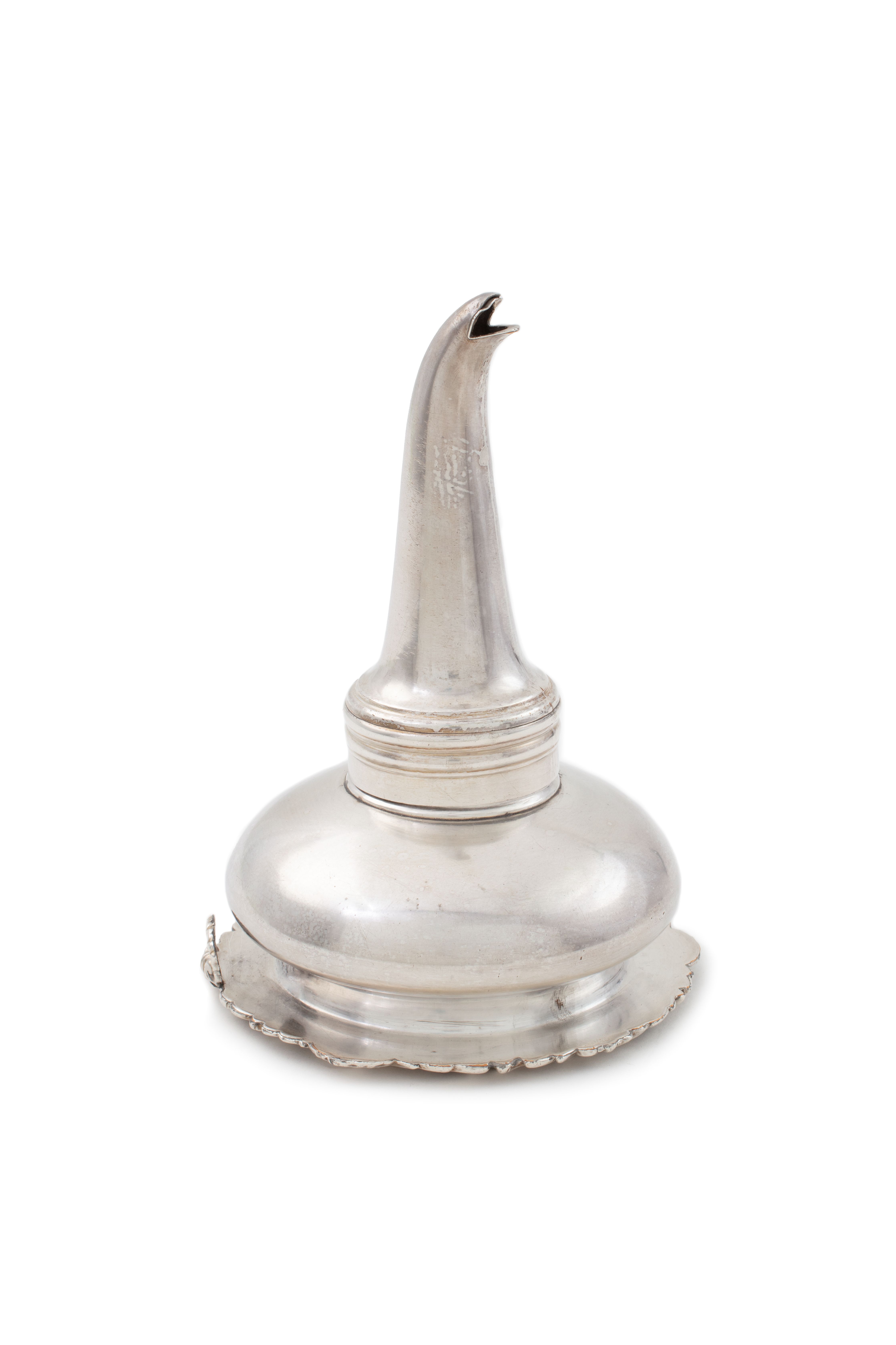 A silver wine strainer in the shape of an upside down funnel.