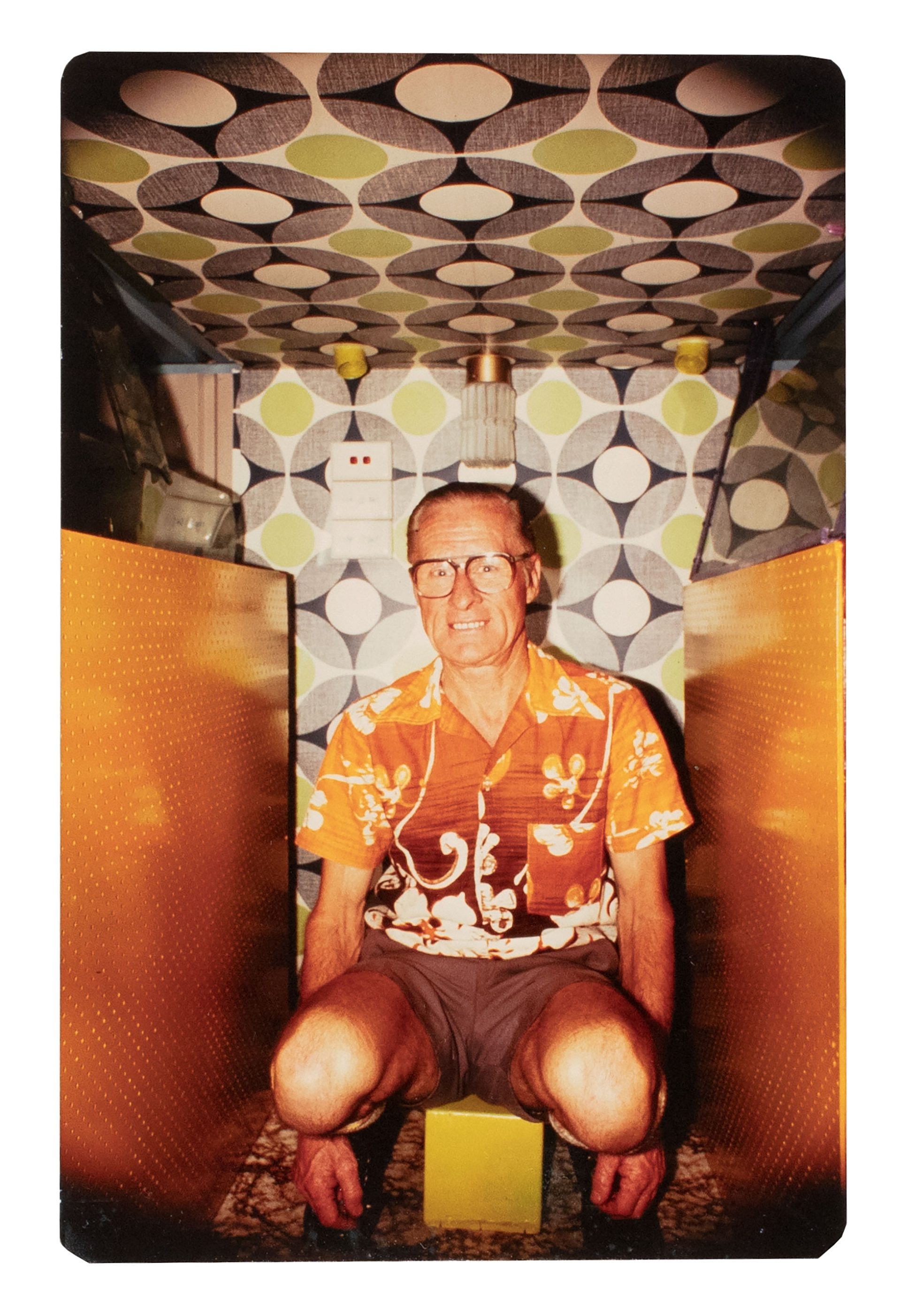 A smiling man sitting in between two oscillator machines.
