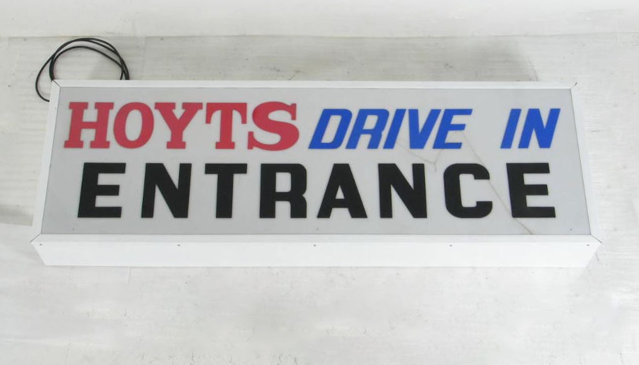 Illuminated rectangular sign consisting of coloured acrylic letters adhered to a white acrylic sheet.