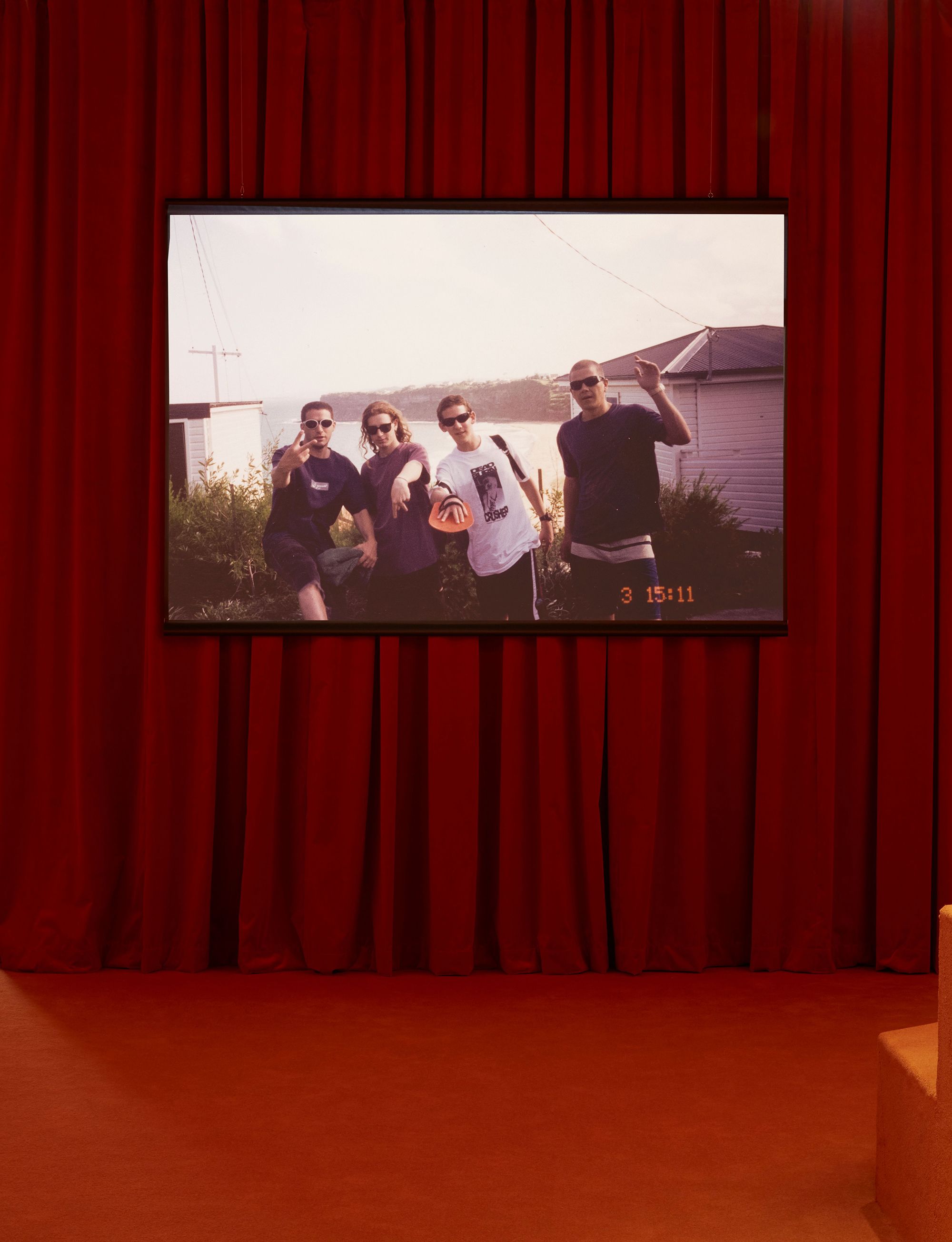 A room with red carpet and a red curtain wall with a screen hanging on it.