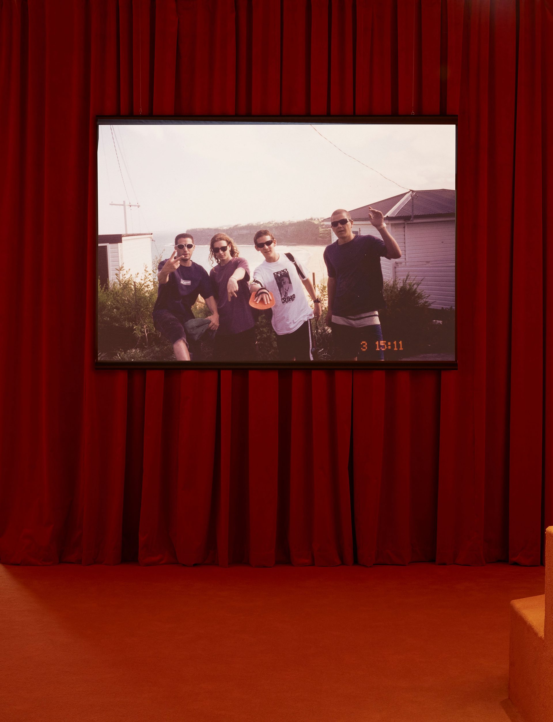 A room with red carpet and a red curtain wall with a screen hanging on it.
