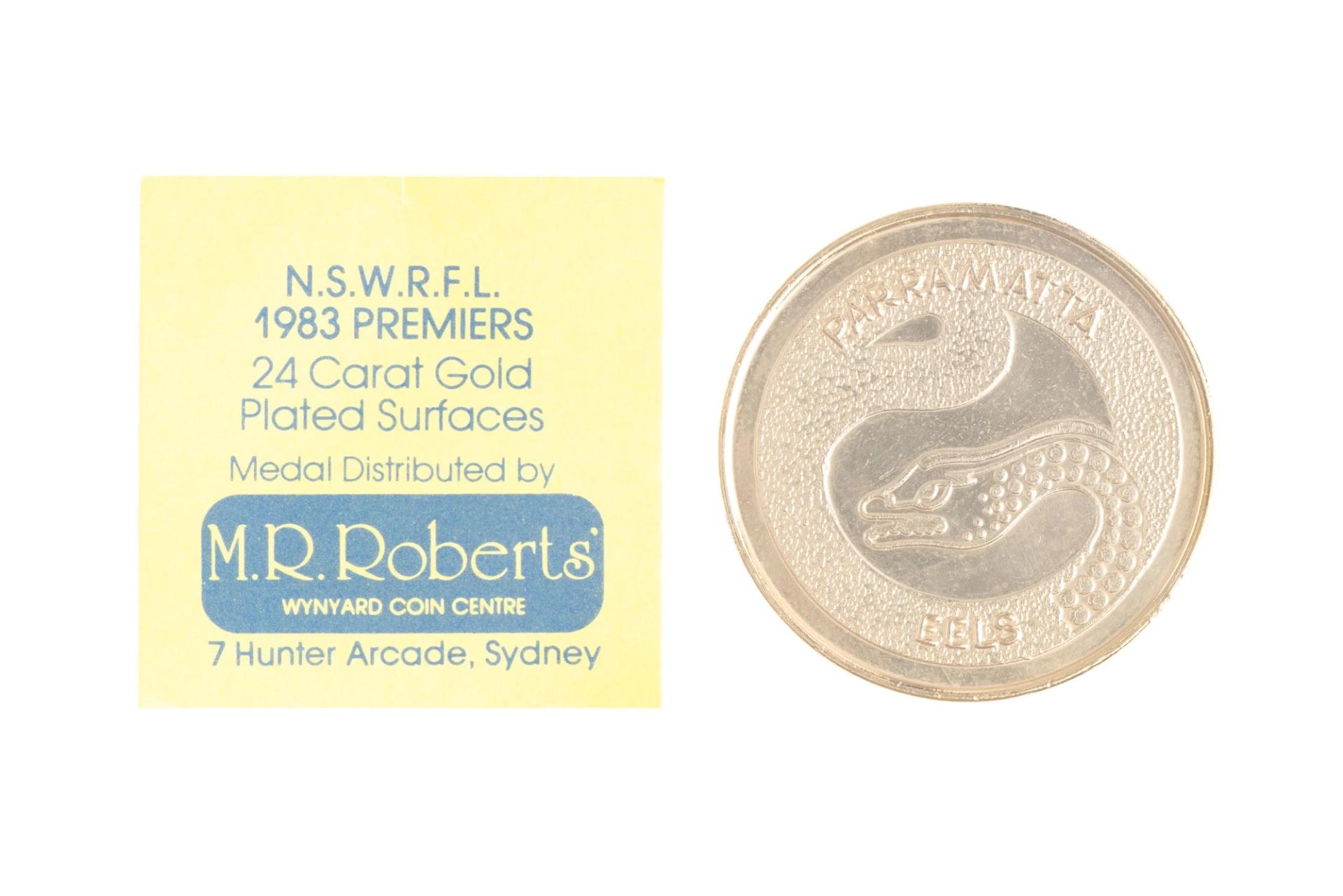 A medal with the New South Wales Rugby Football League crest with text around the edge 'New South Wales Rugby League. Premiers 1983'.