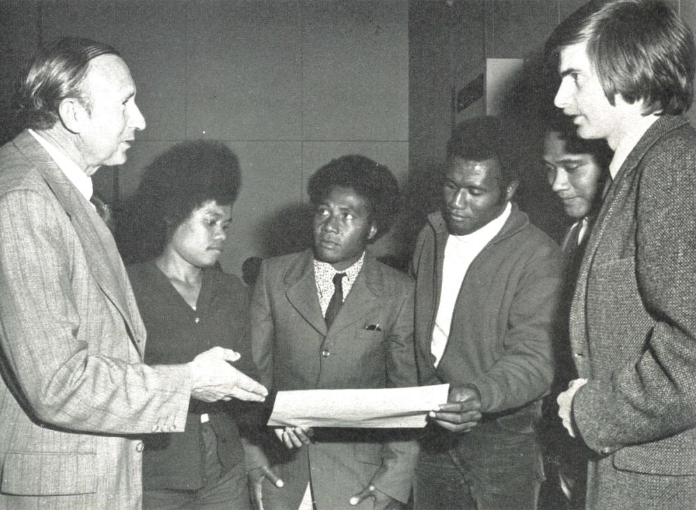 Six people exchanging a piece of paper