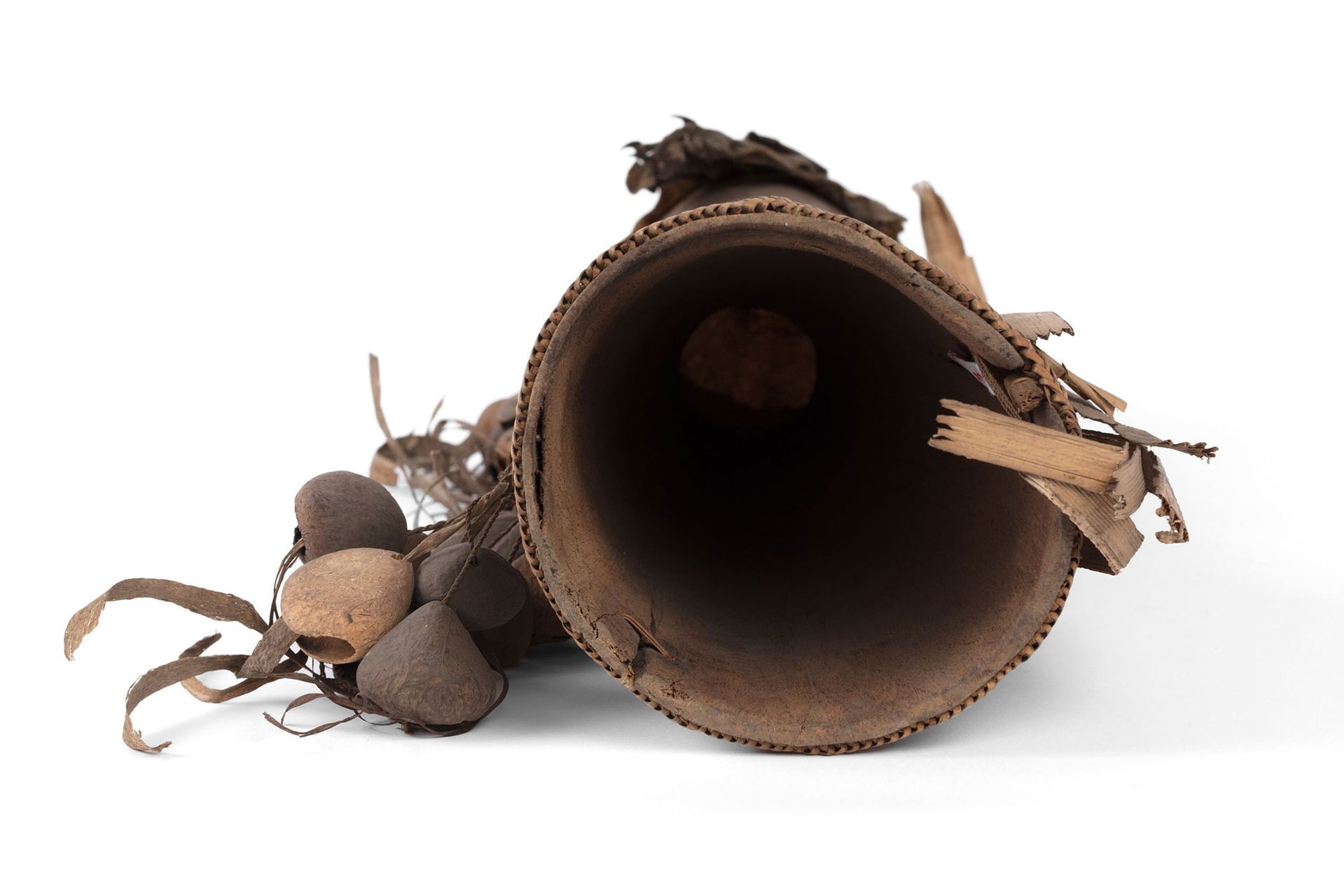 A small brown hand drum made with goanna skin and seed pods.