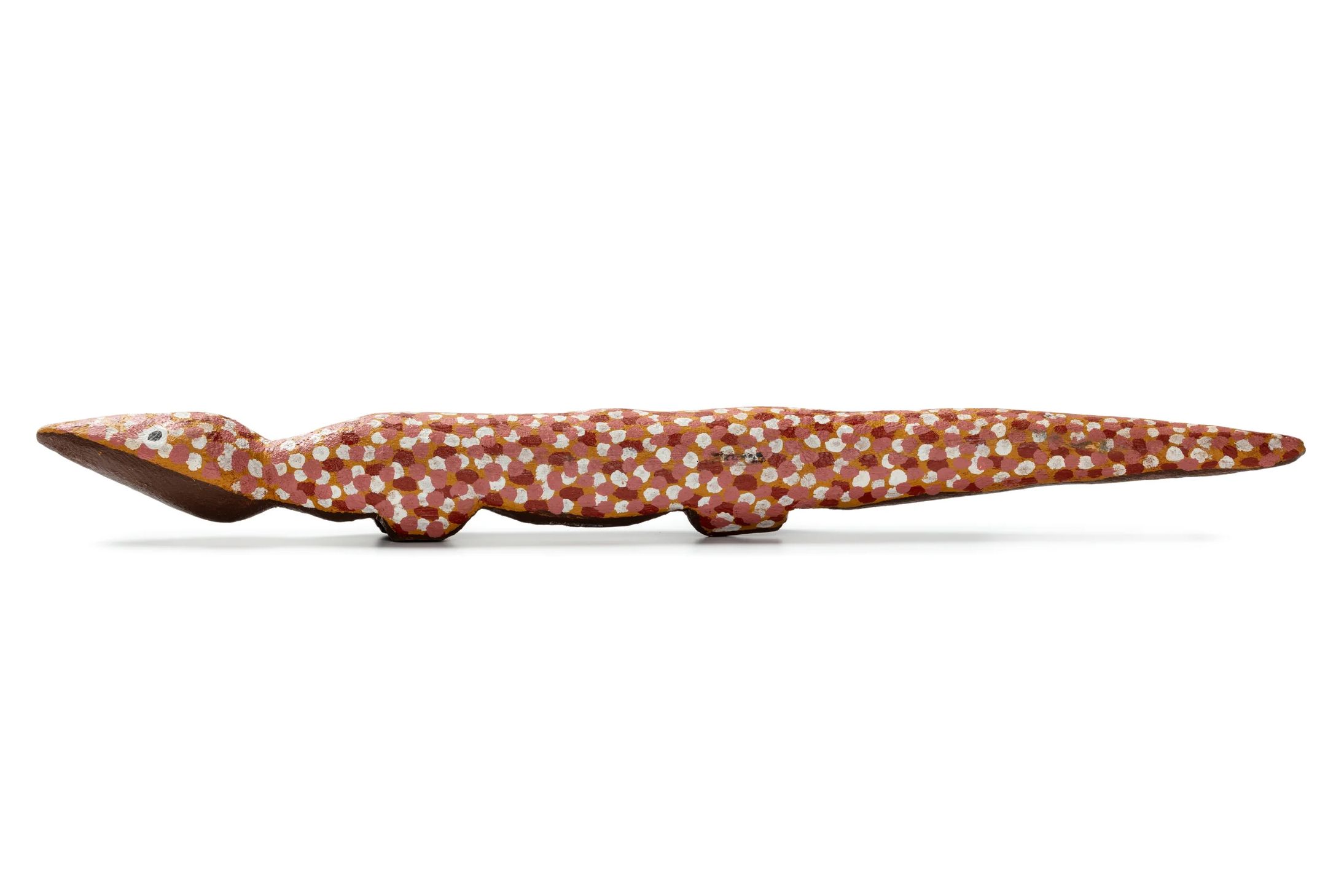 Orange carved goanna from a softwood, painted with red and white dots.