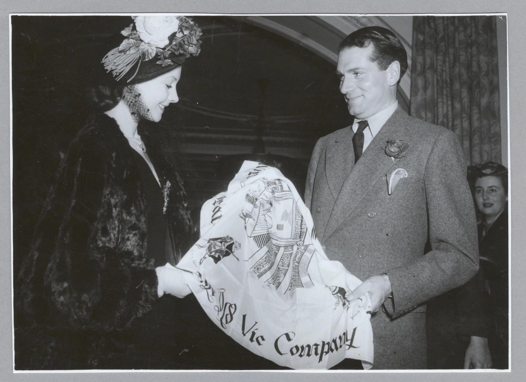 A scarf being presented to two people.