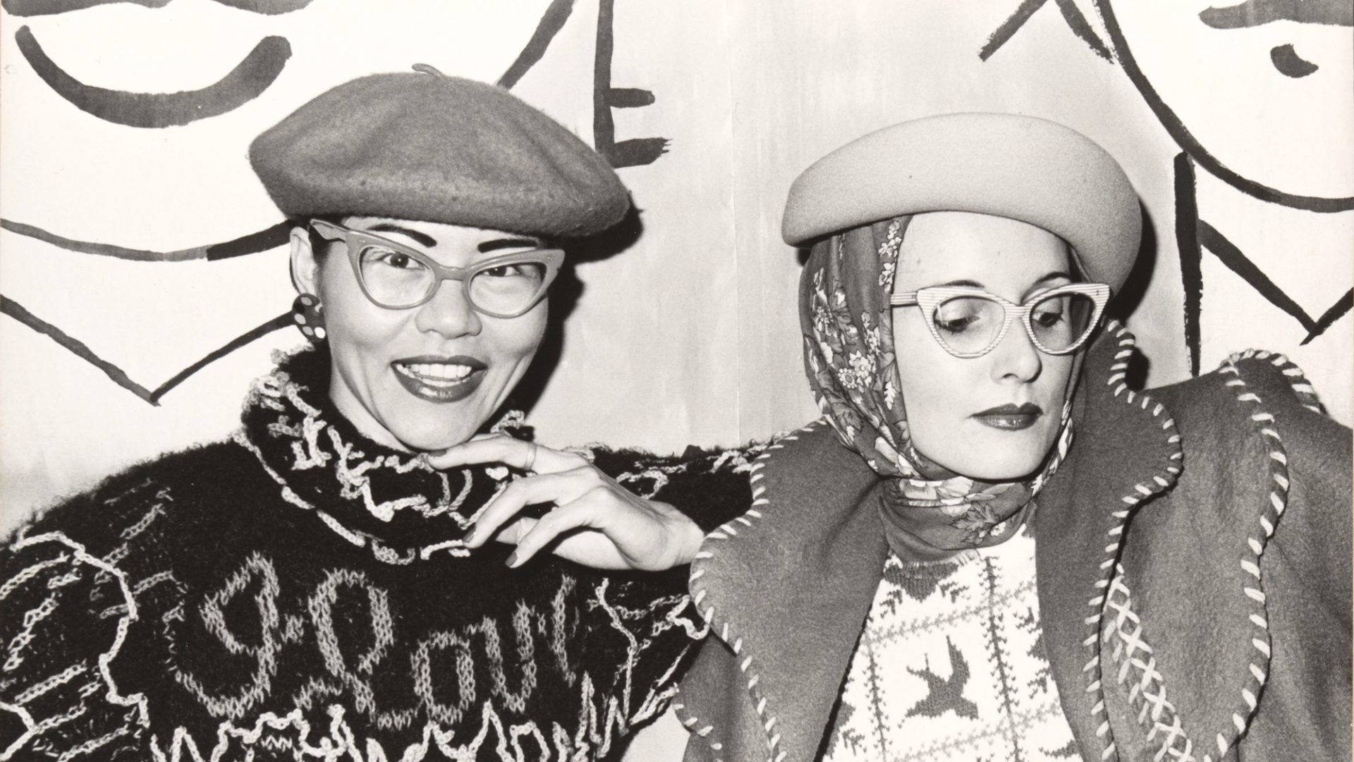 A black and white photograph of designers Jenny Kee wearing a Kee designed knit and Linda Jackson wearing a Linda Jackson designed jacket.