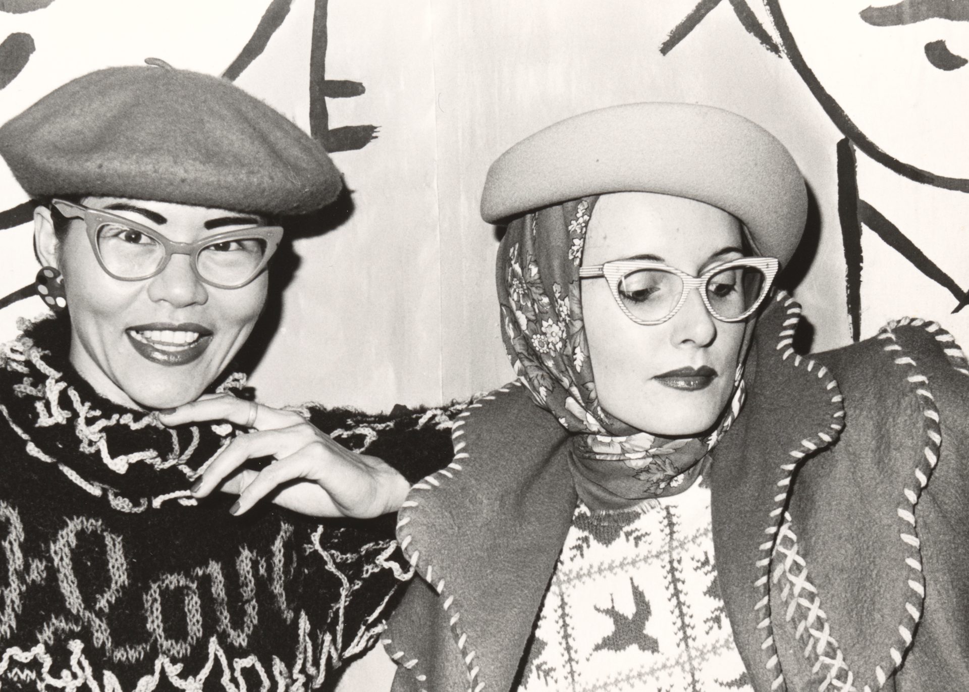 A black and white photograph of designers Jenny Kee wearing a Kee designed knit and Linda Jackson wearing a Linda Jackson designed jacket.