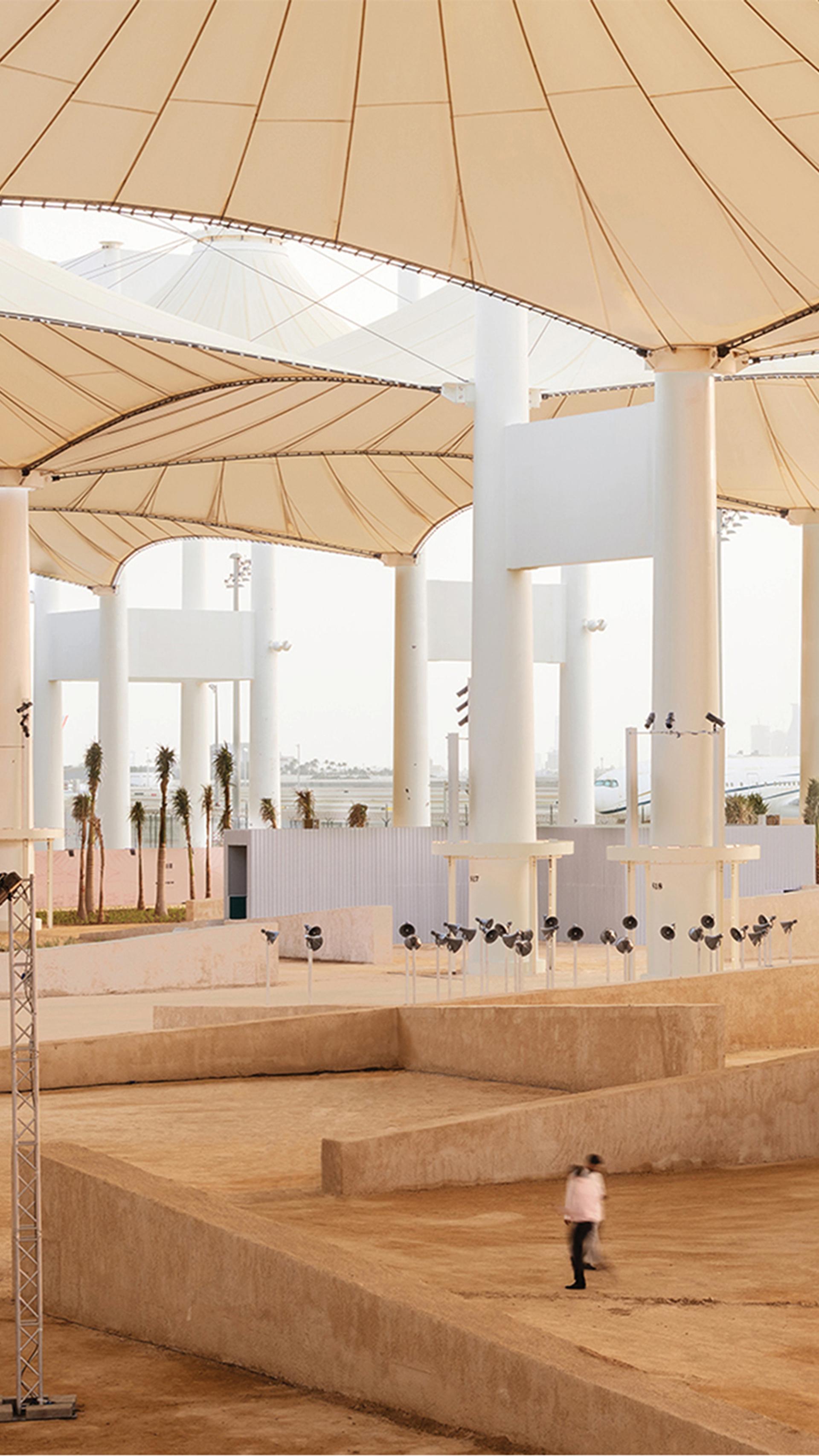 Large installation space outside, under giant umbrellas.