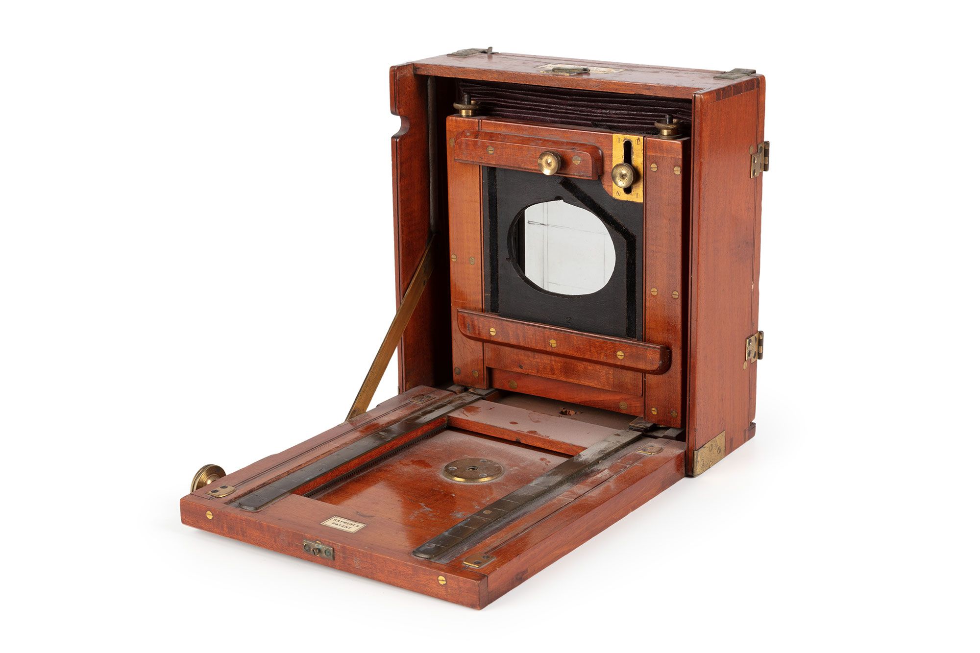 Wooden box with the front opened. Inside a compressed camera is secured.