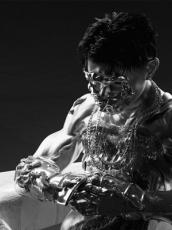 A 3D rendered figure with silver armour on their face, chest, and forearm.