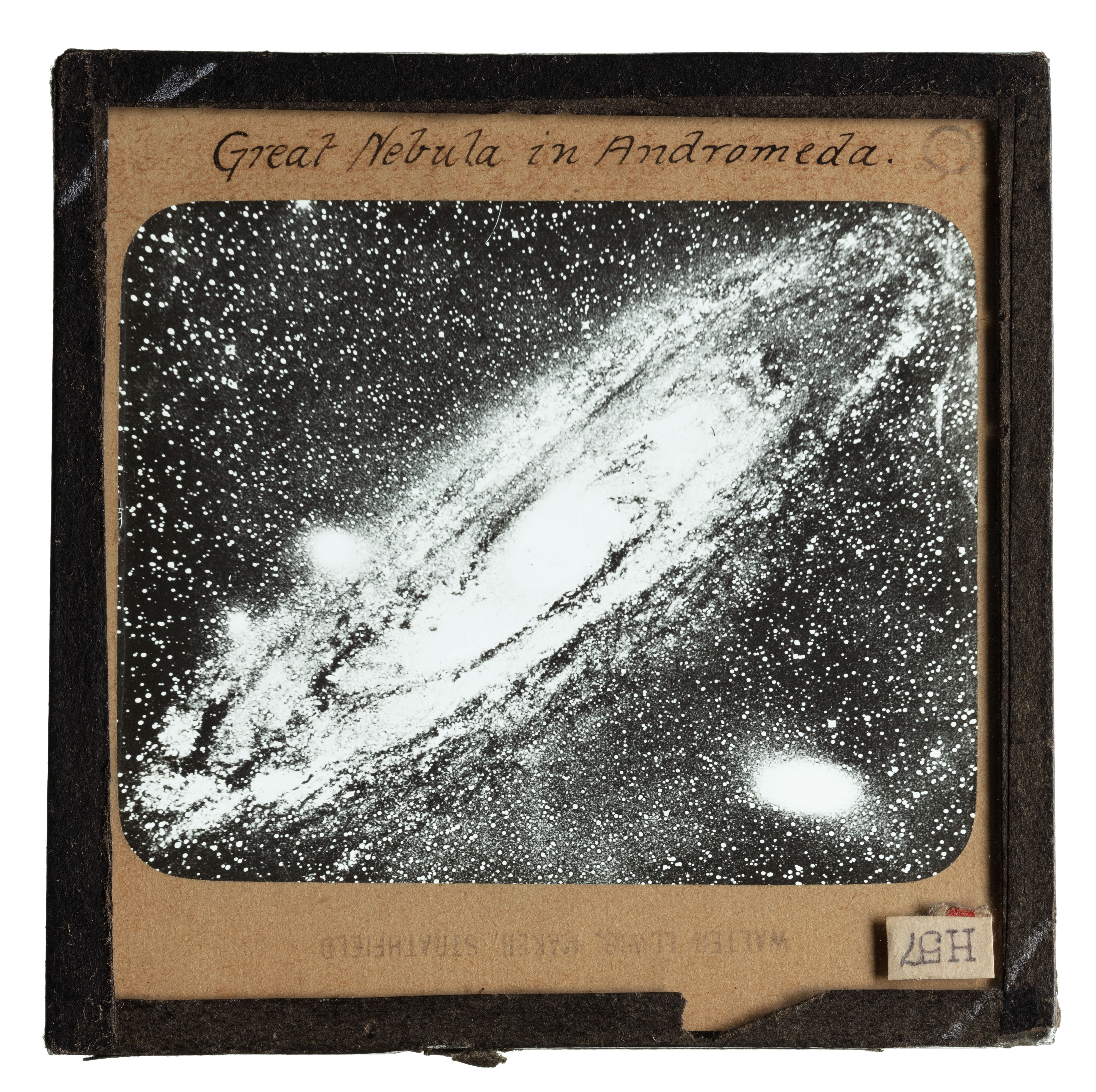 Photograph of a glass plate slide with a black frame and an image showing the 'Great Nebula in Andromeda'.