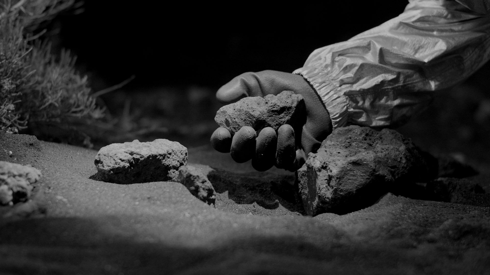 Gloved hand holding a rock