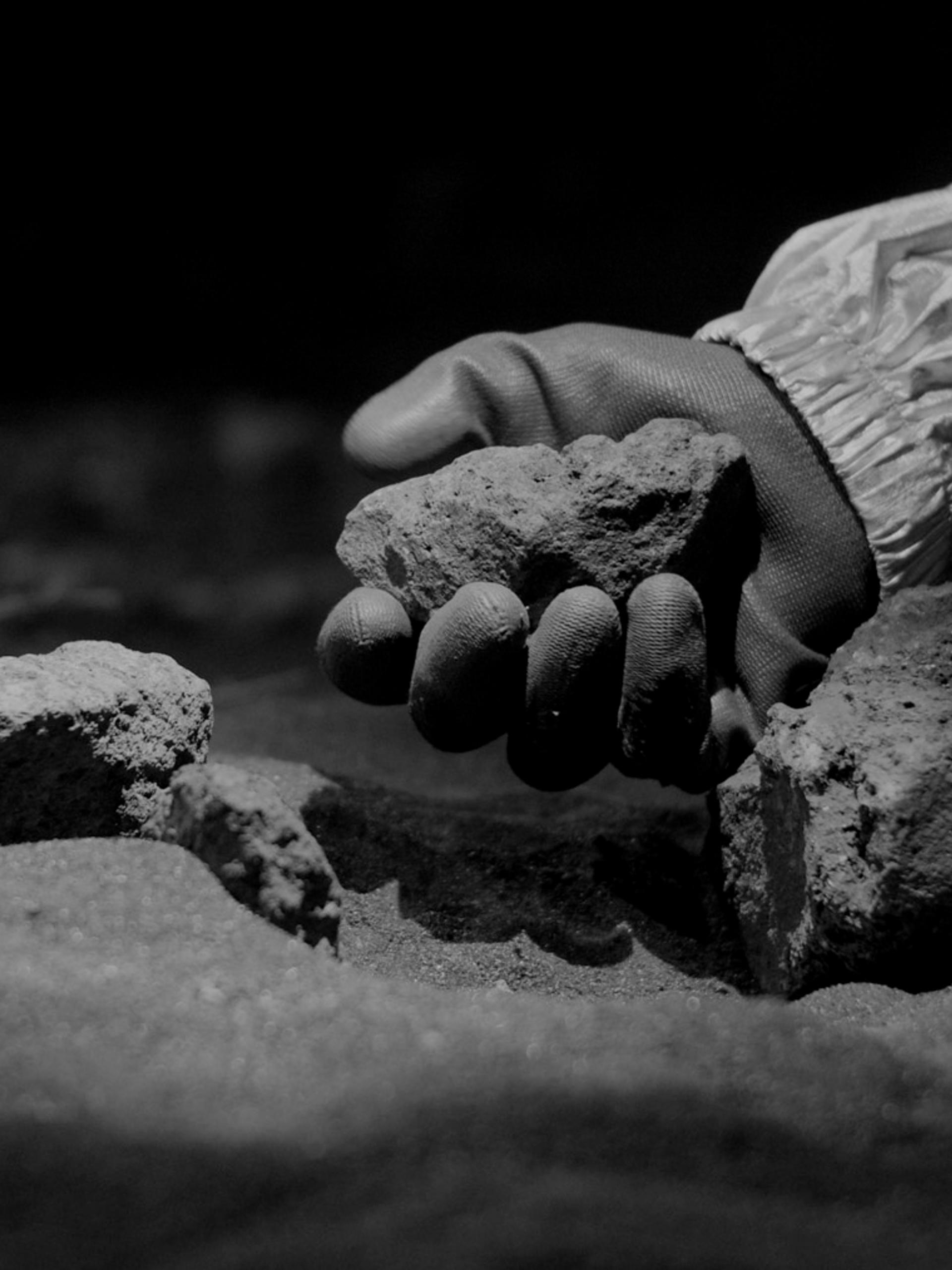 Gloved hand holding a rock
