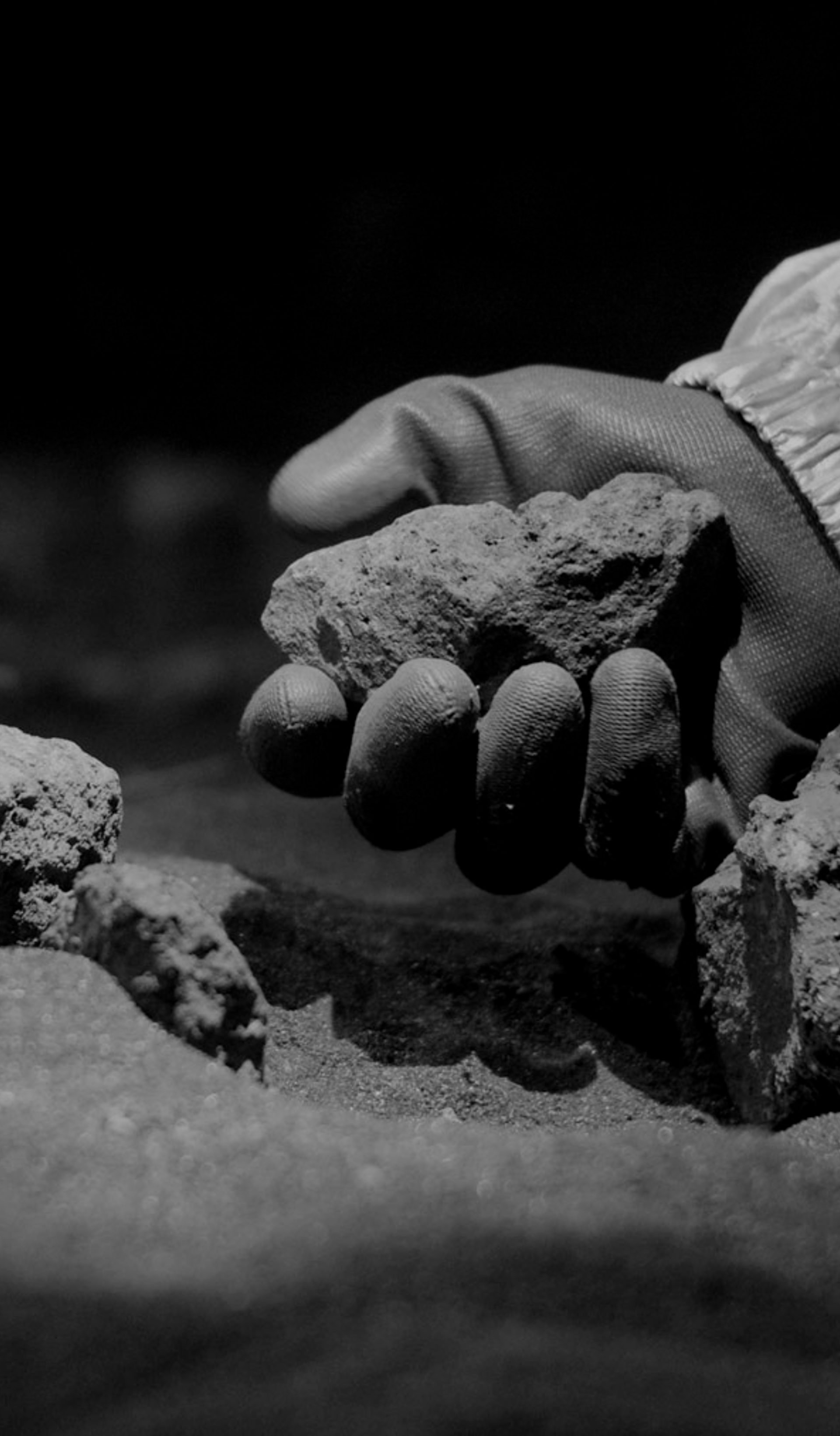 Gloved hand holding a rock