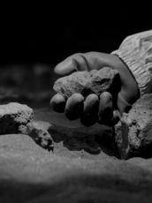 Gloved hand holding a rock