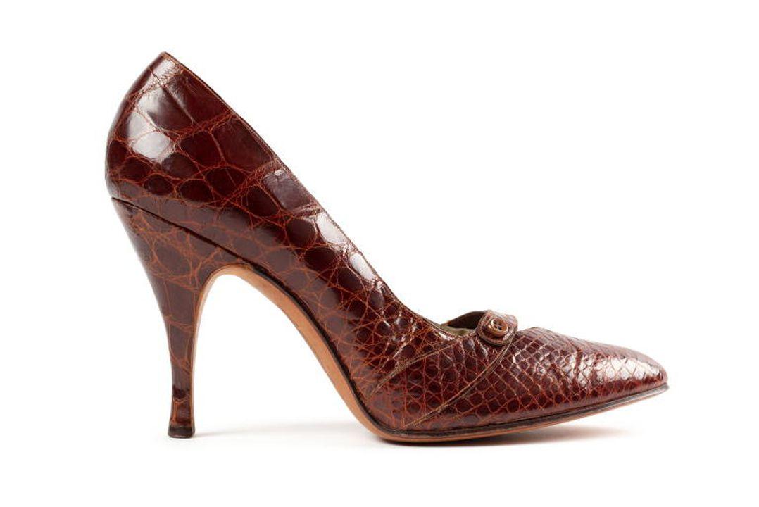Pair of ladies' dress shoes of brown skin, either crocodile or lizard, trimmed at the front with a small brown skin strap and button