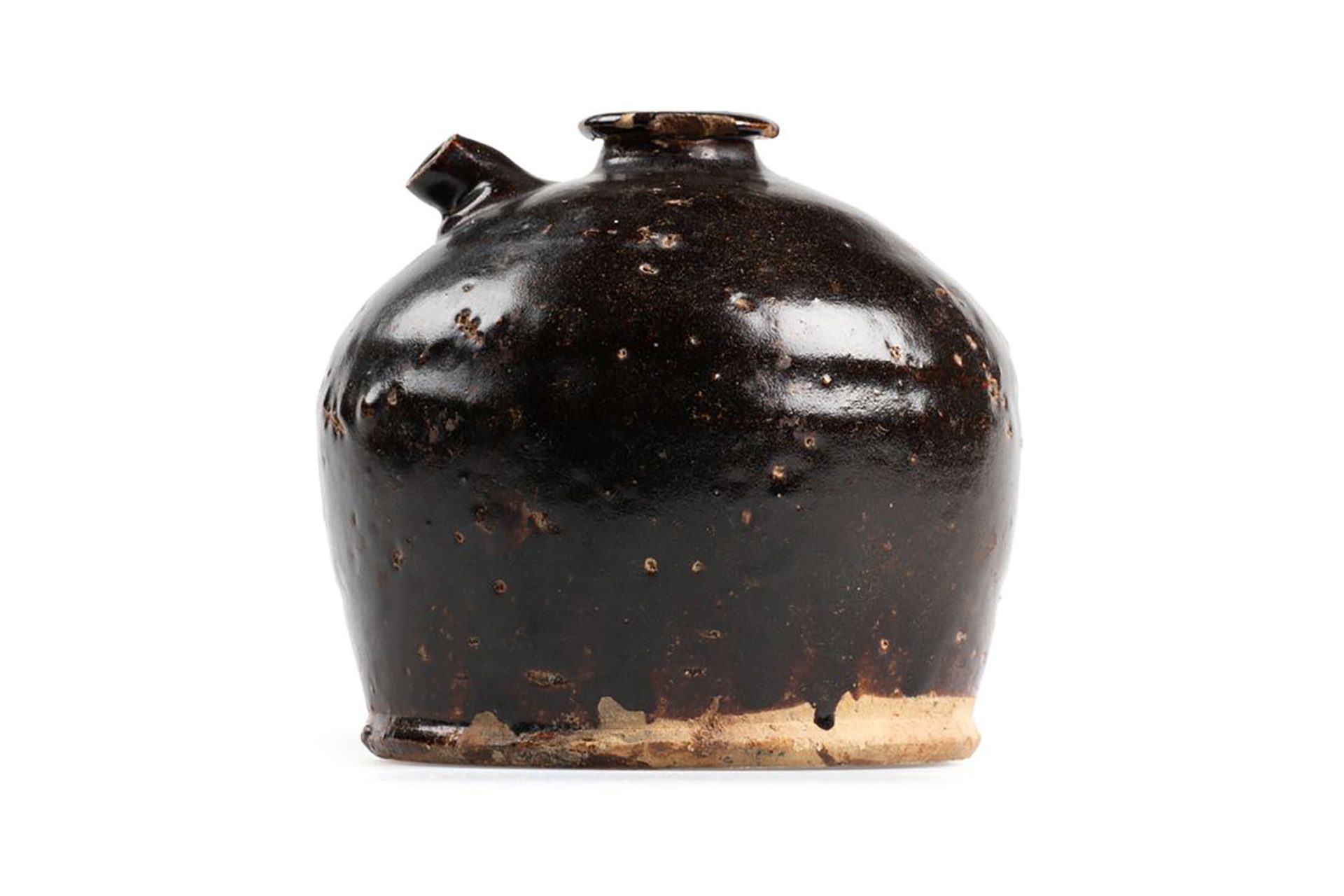 Hand-made circular ceramic jar without a lid. It is glazed in dark brown. The underside has no glaze or markings. There are two openings at the top, one for filling the jar with sauce, the smaller opening for pouring.
