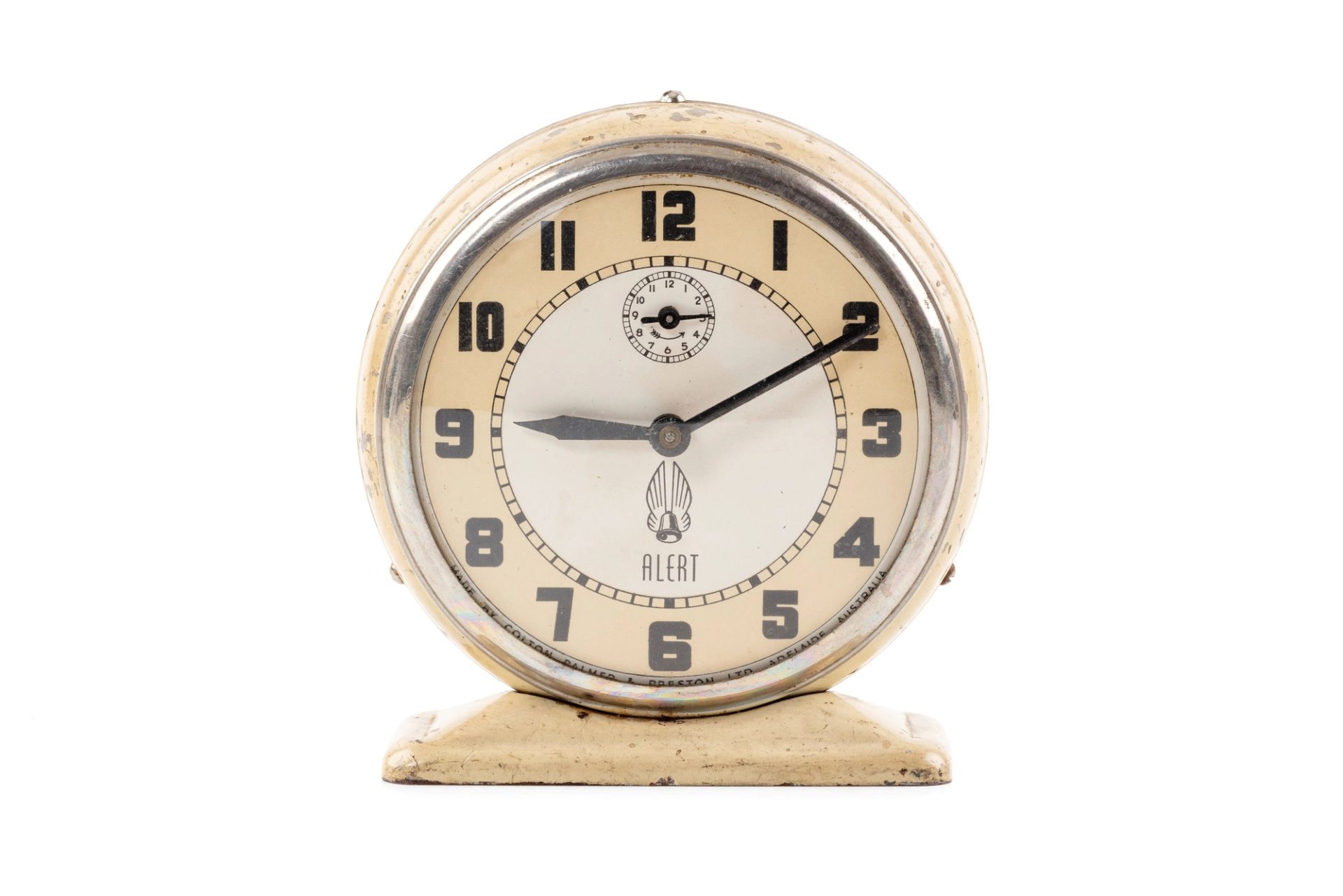 A cream, white and silver alarm clock with a circular face, on a white background