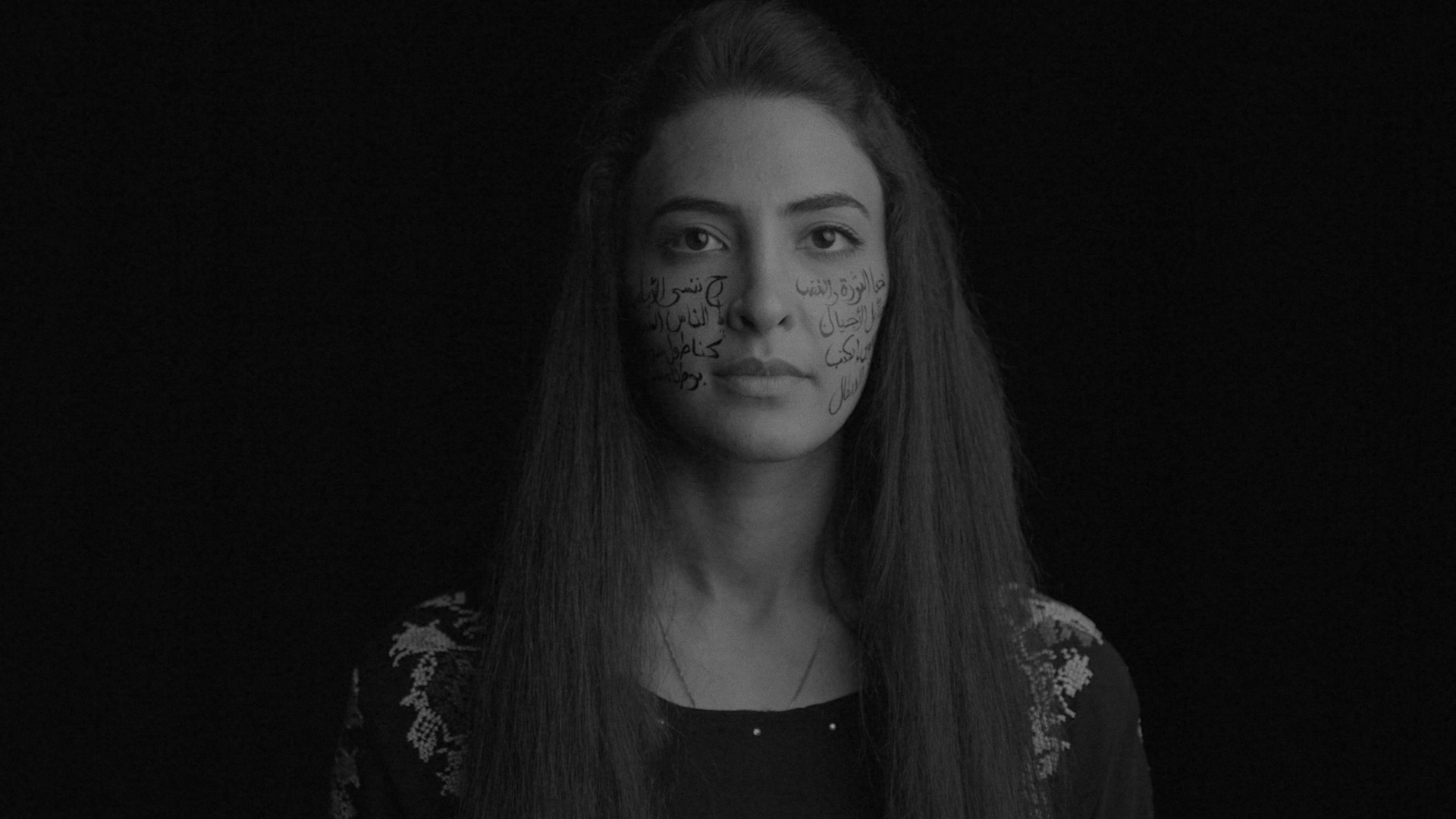 A Palestinian woman with Arabic text across her cheeks.